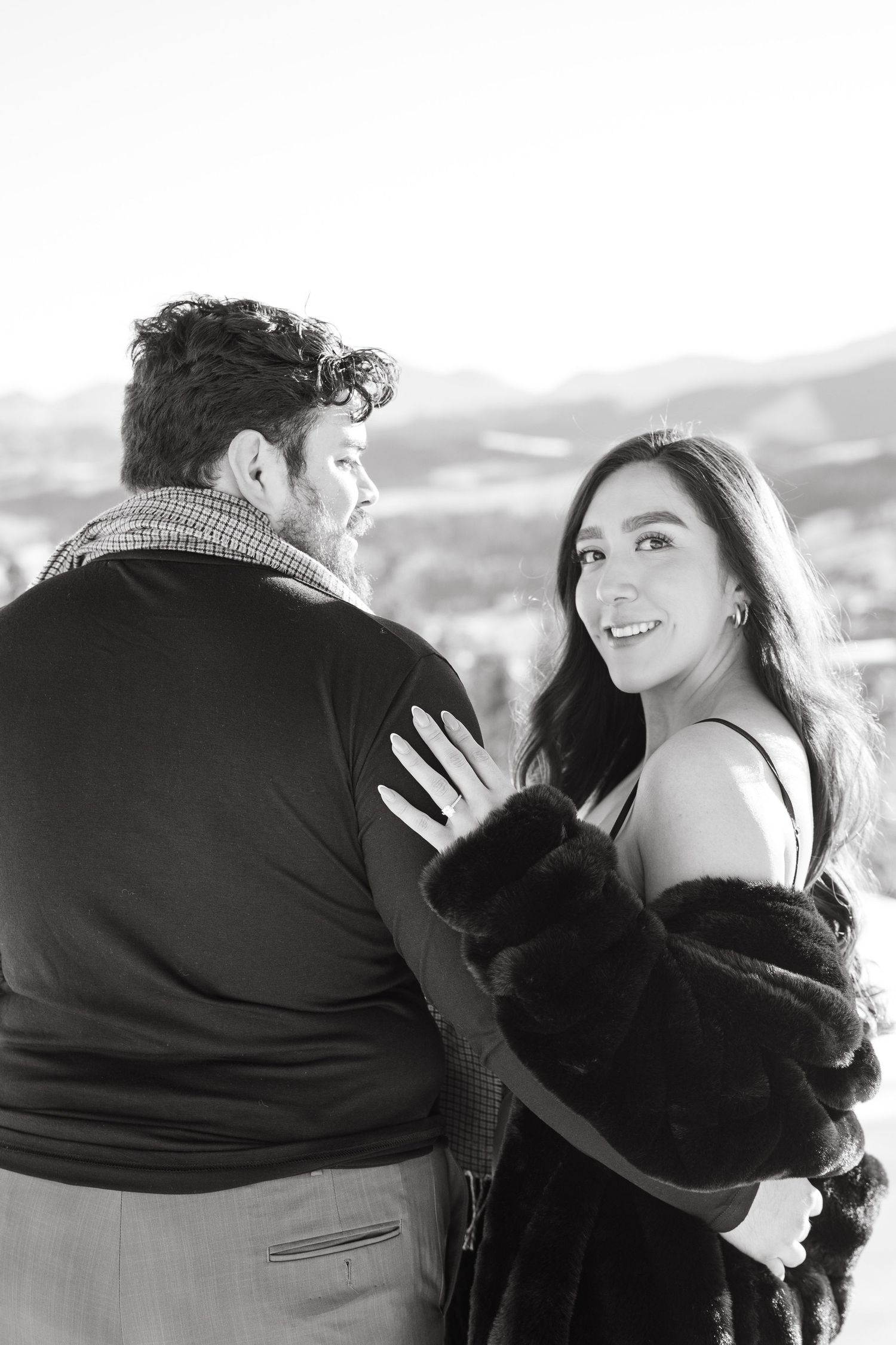 Black and white photo series showing a romantic couple embracing and smiling together outdoors.