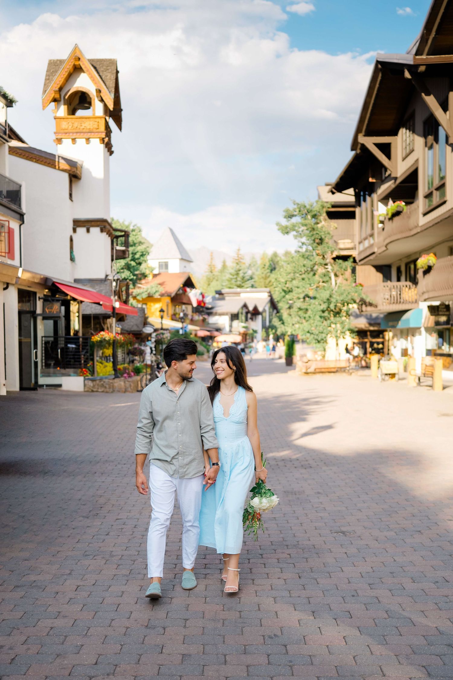 A couple walks through vail village after proposal -  a charming European-style village street with rustic architecture and brick pavement.