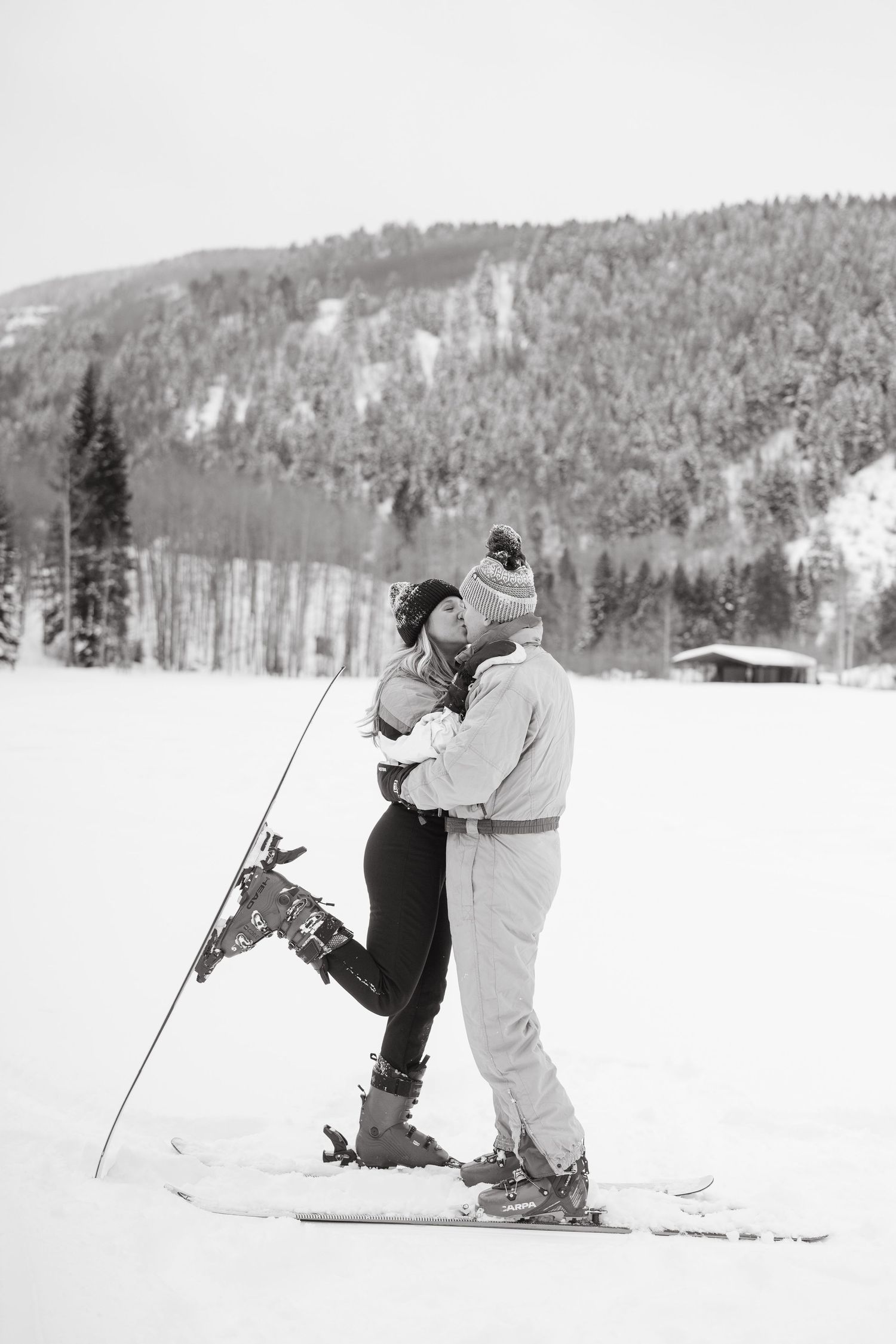Playful couple shares romantic moments while skiing on snowy slopes.