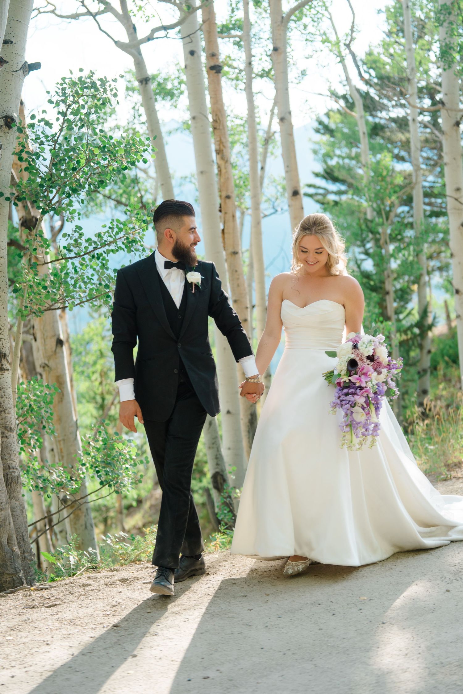 A couple shares romantic moments in a wooded outdoor setting during their Breckenridge wedding celebration