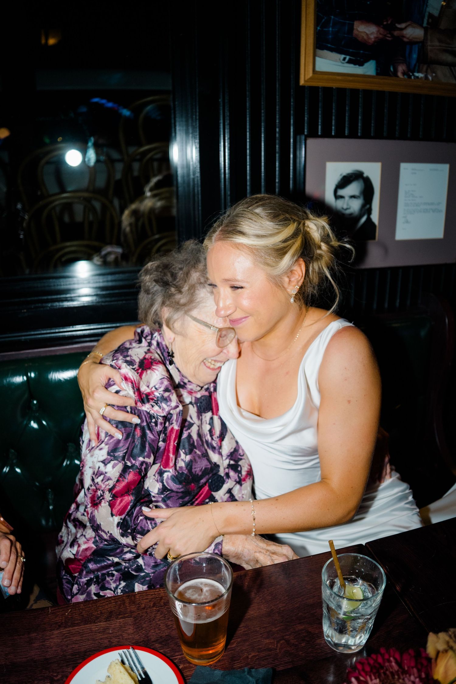 Two people share an intimate moment at a restaurant table with drinks and laughter.