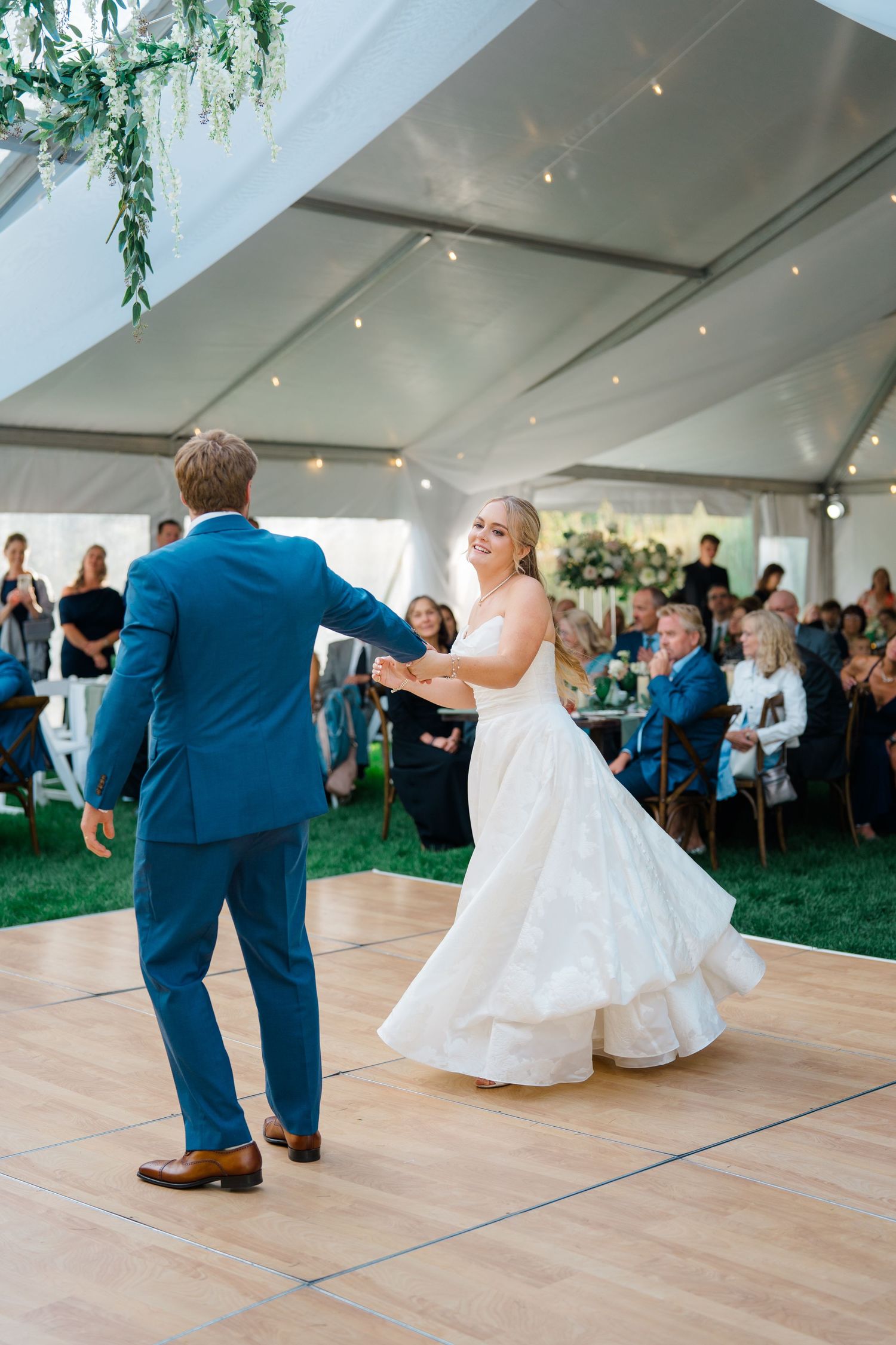 Wedding reception dance photos showing couples twirling and dancing together under a white tent with string lights.