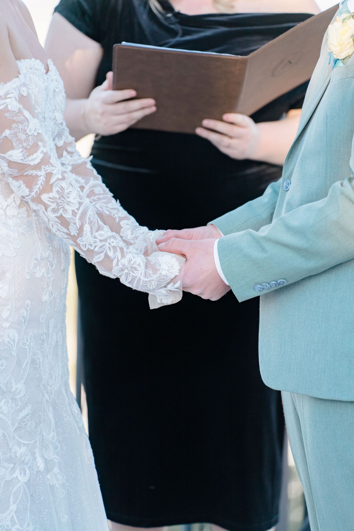 bride and groom holding hands during ceremony