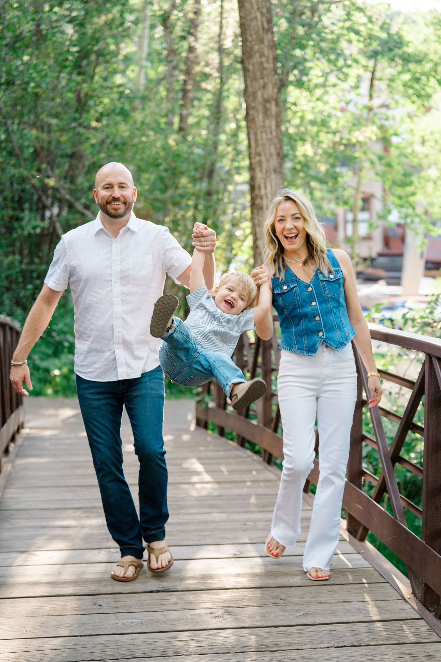 A playful family photo sequence on a wooden bridge in a forest setting.