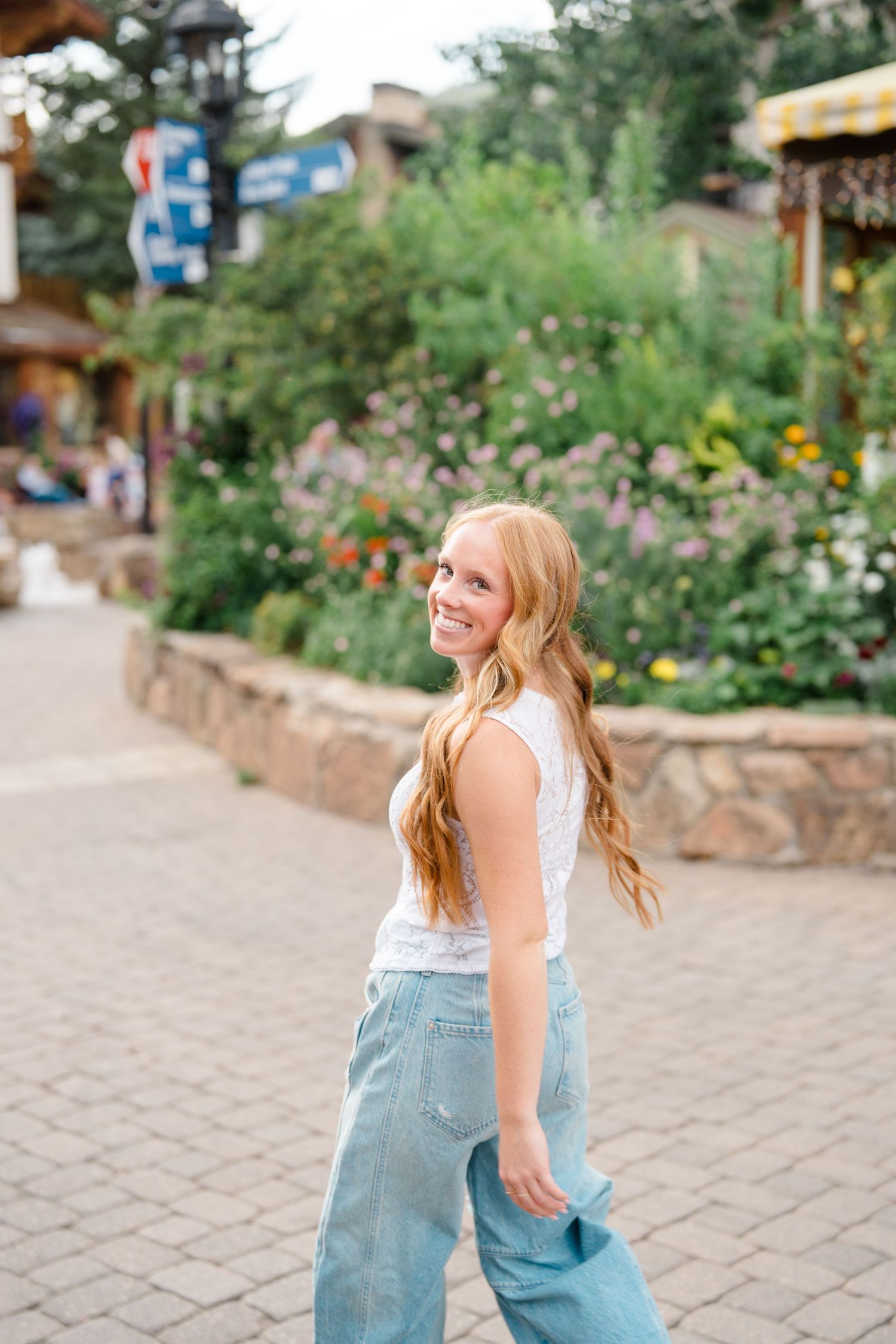 A casual summer outfit shines against a backdrop of colorful mountain town gardens during vail senior photography session.