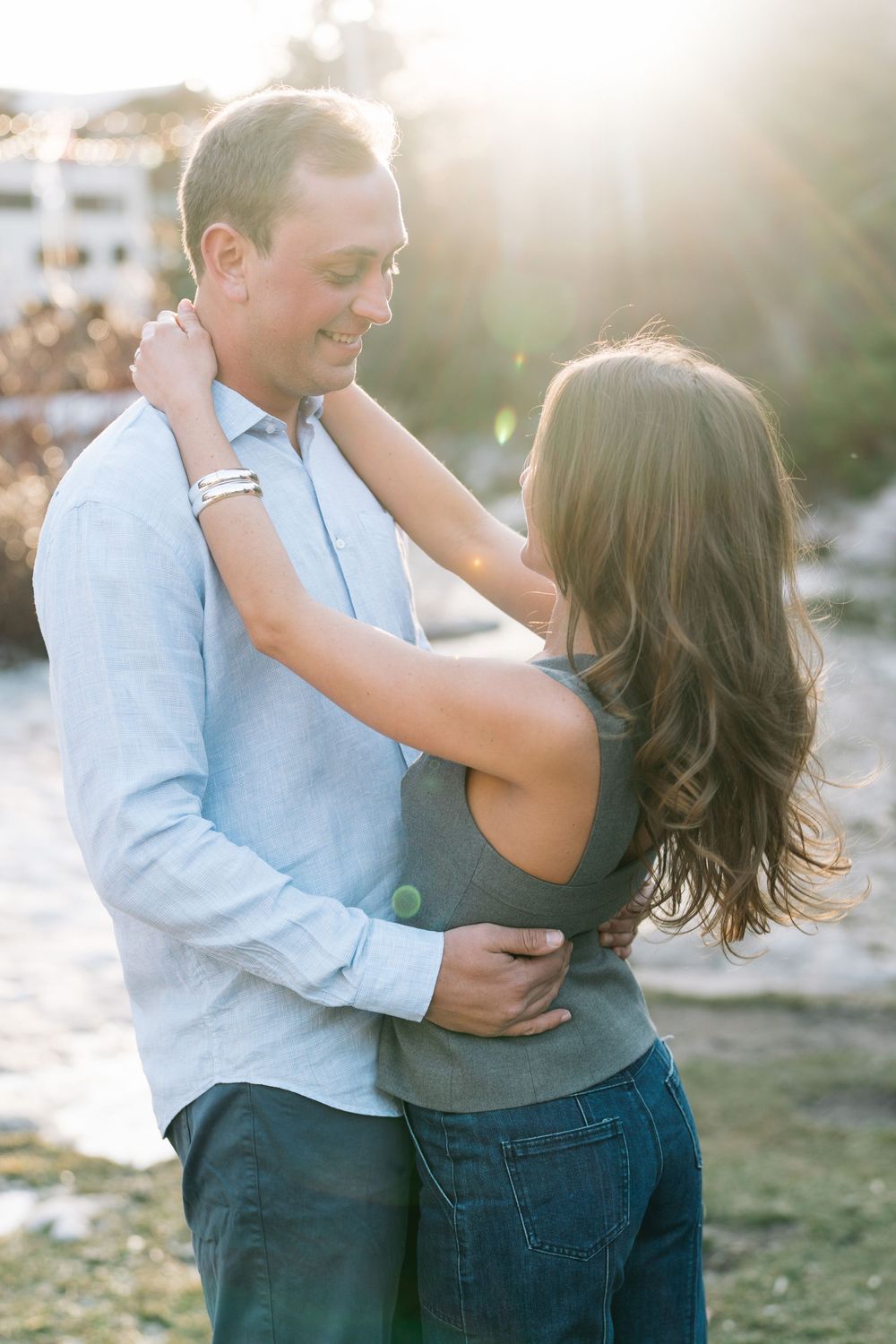 A romantic couple embraces during golden hour sunset by the water during vail engagement photography session.
