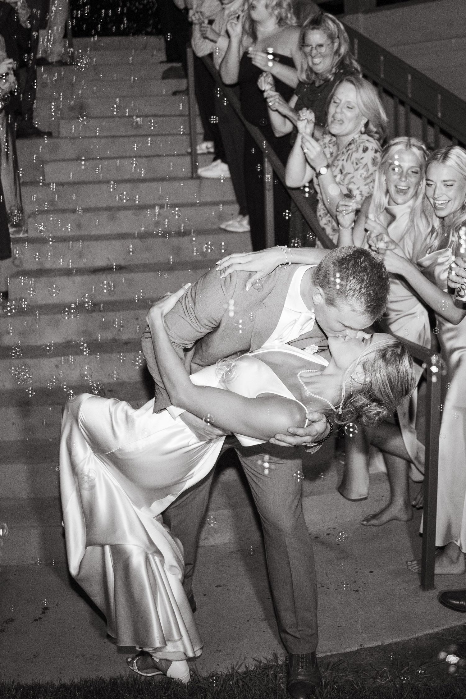 A vintage black and white sequence showing a wedding party having fun on outdoor steps.