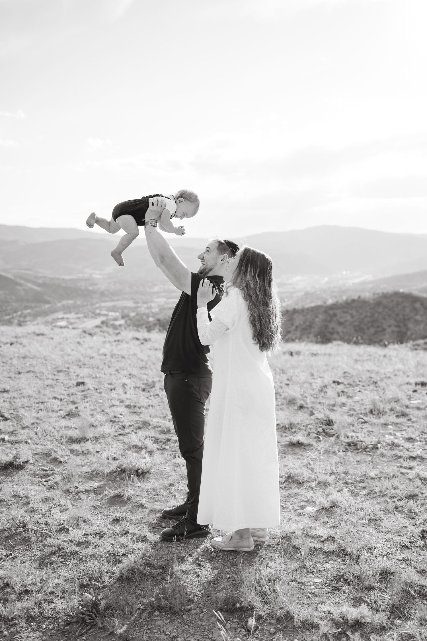 A couple shares a romantic dance pose against a mountainous black and white landscape.