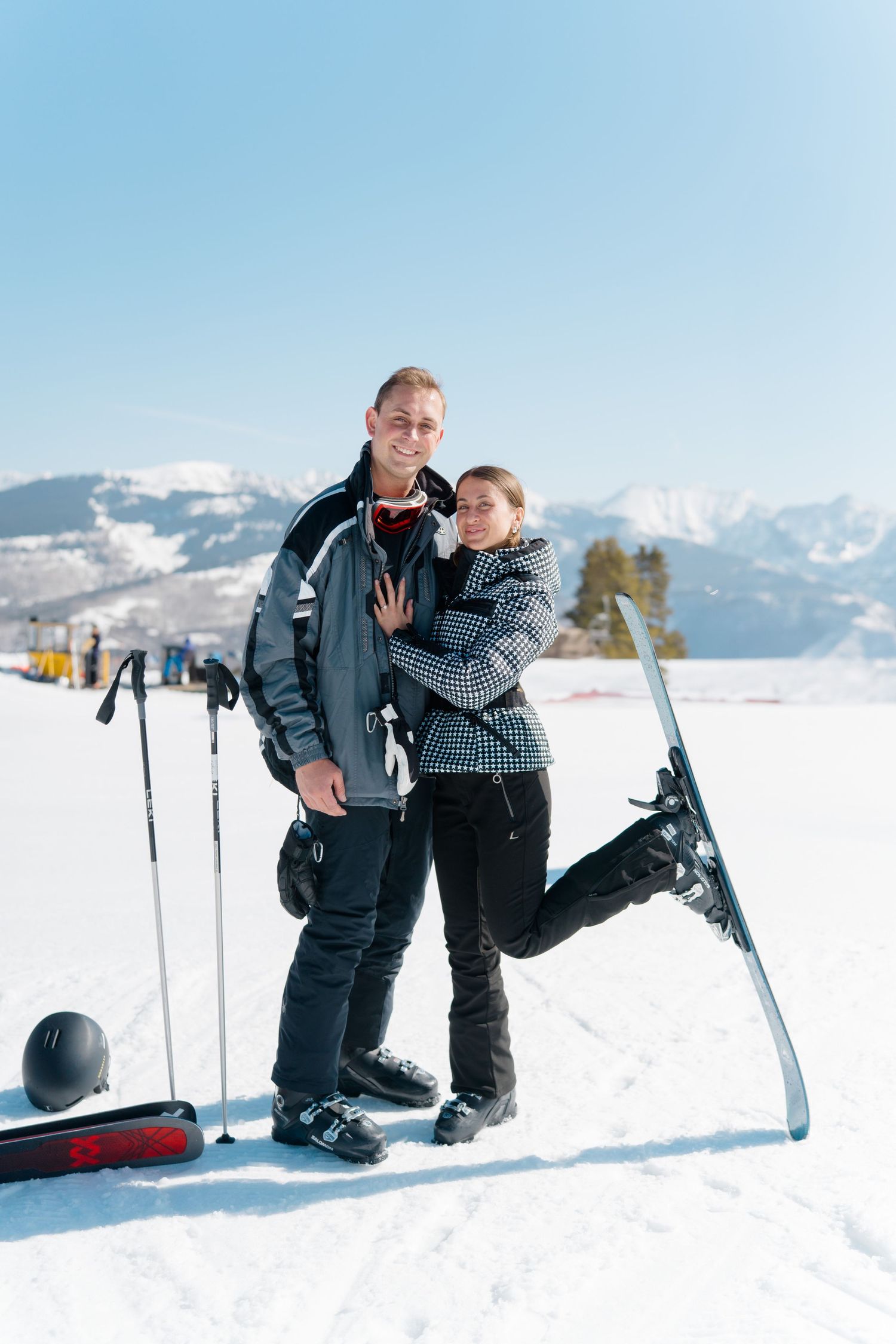 guy and girl standing by mountain after getting engaged during vail ski proposal session.