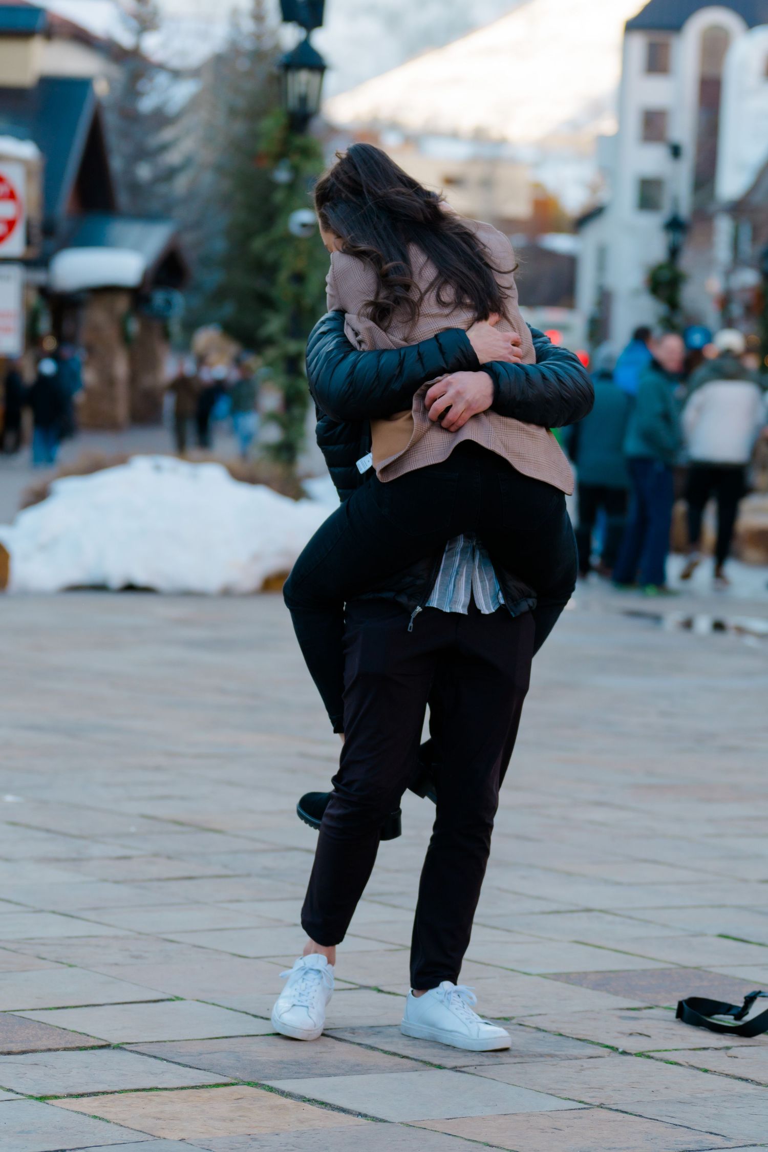 Close-up sequence of feet performing a street dance move on tiled pavement.