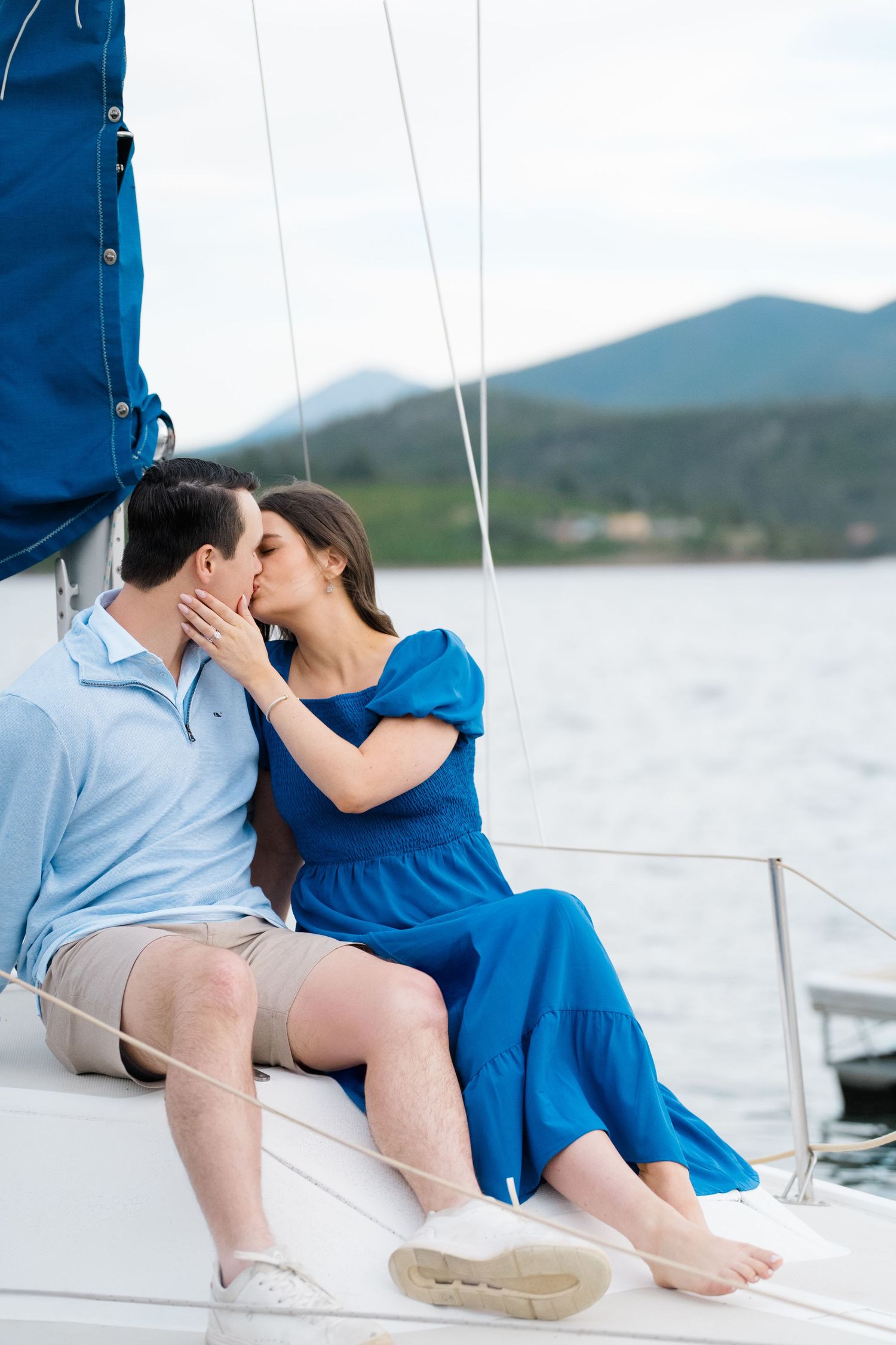 guy and girl kissing on a boat after they just got engaged