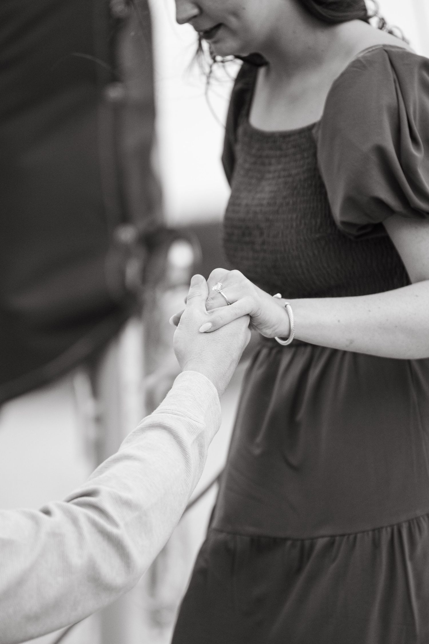 Black and white photo showing hands adjusting a dress sleeve in an elegant, delicate manner.