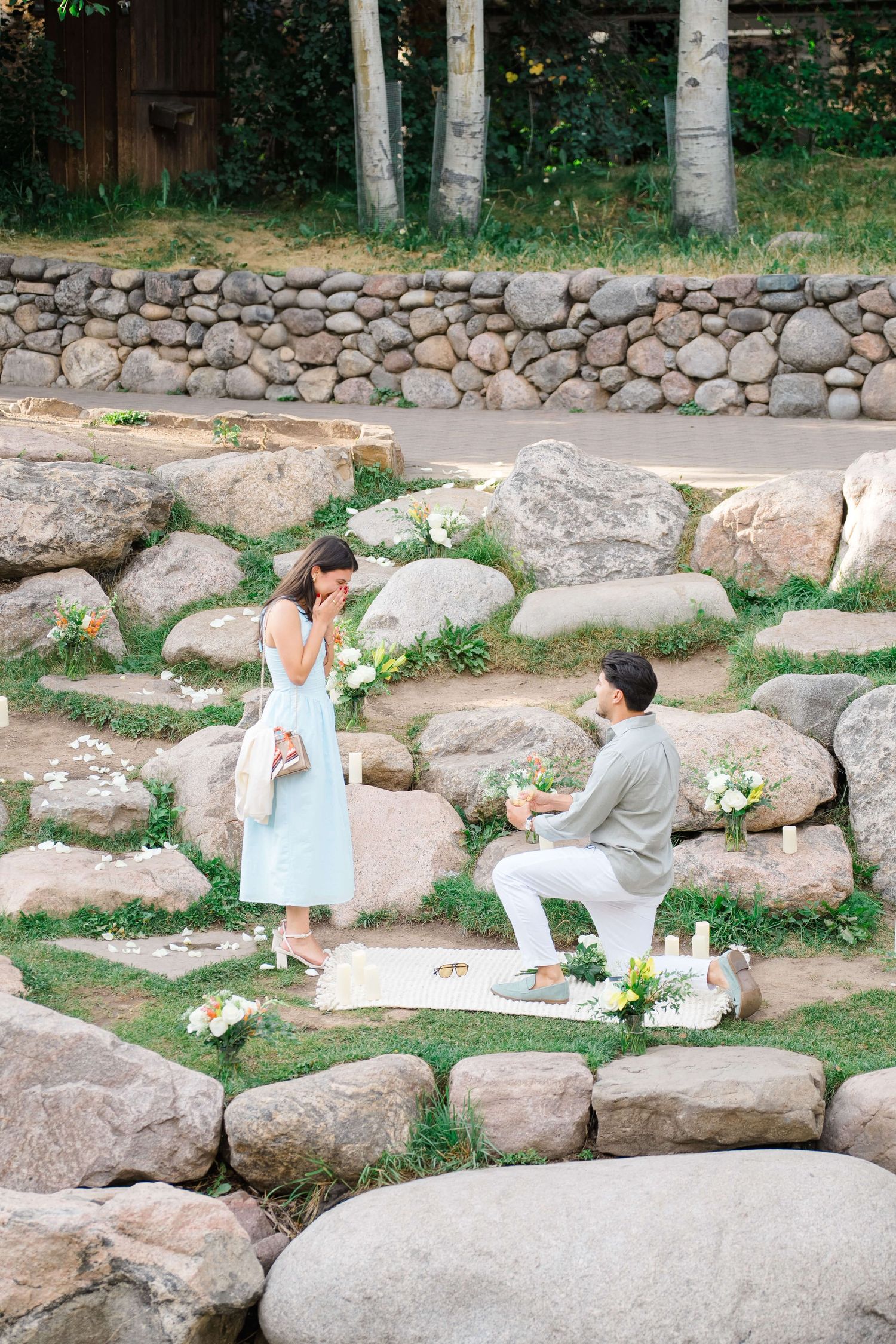 Vail Village Proposal as guy gets down on one knee and proposes to girl in blue dress
