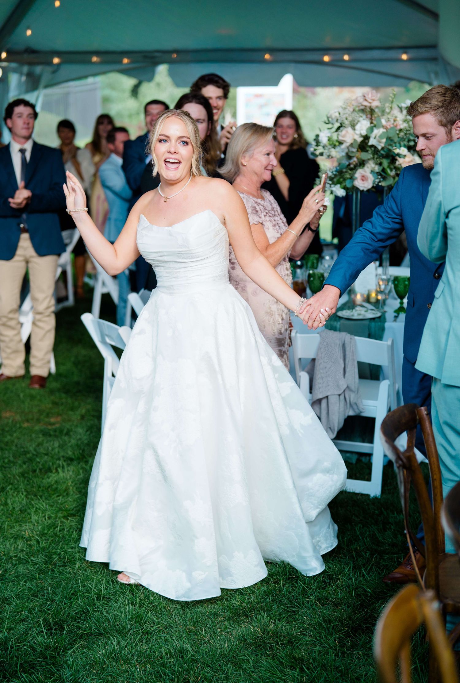 Wedding reception celebration on grass with string lights and guests in casual attire at vail wedding.