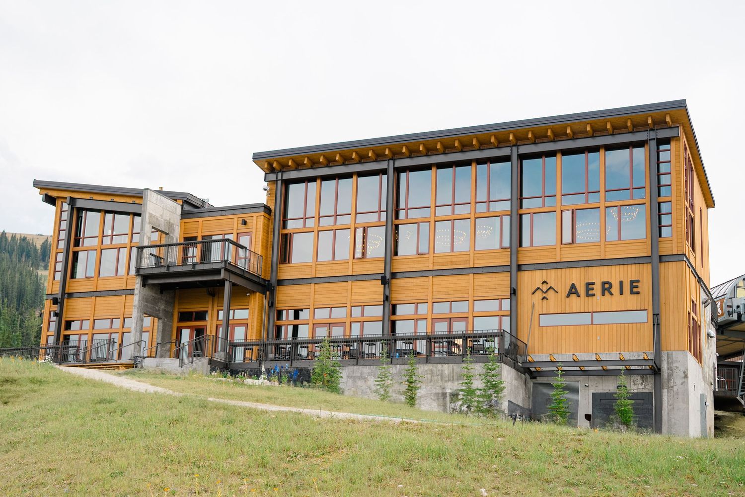 Modern mountain cabin with wood and glass exterior features expansive windows overlooking a scenic hillside landscape at copper mountain.