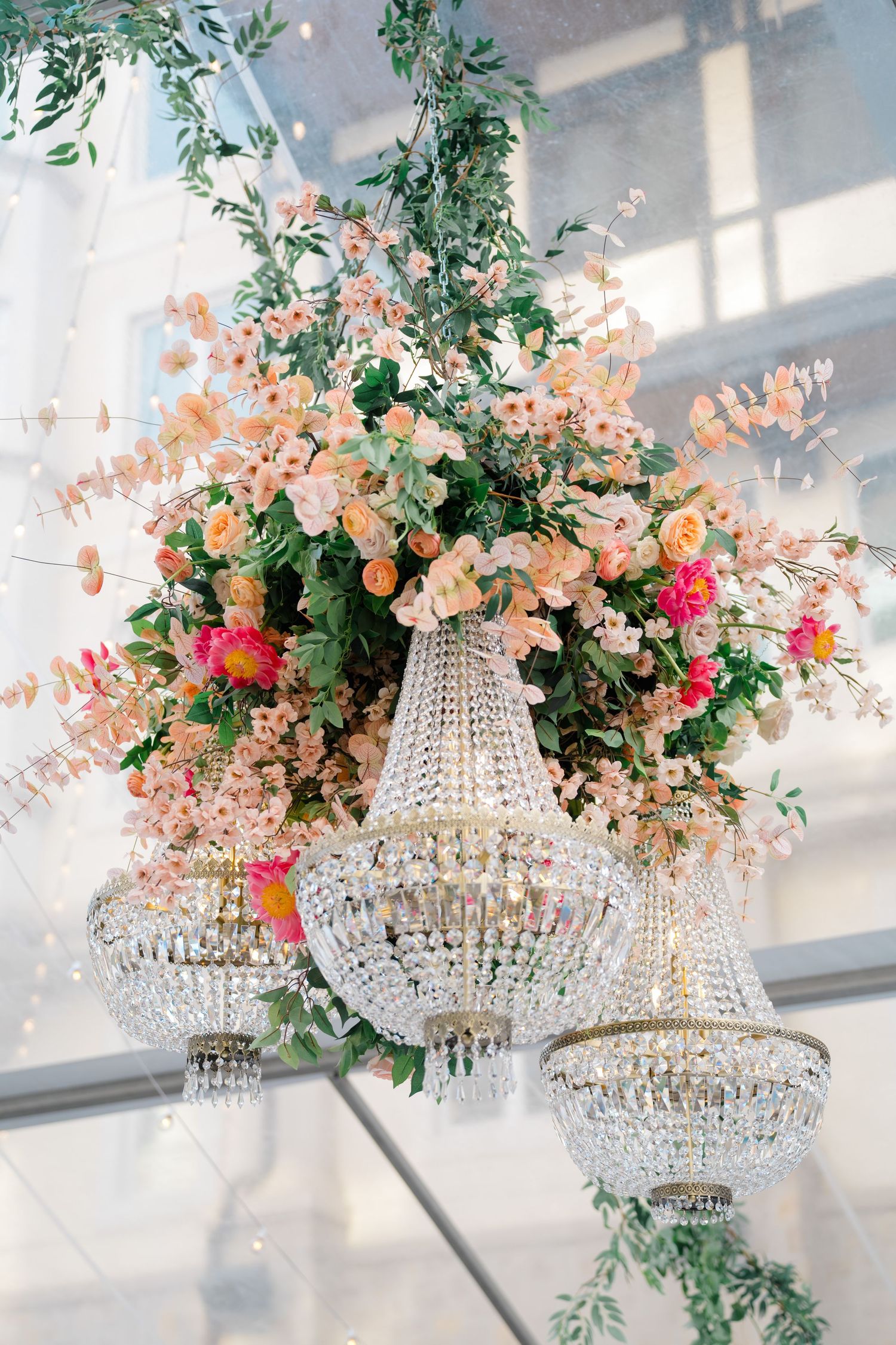 Crystal chandelier with gorgeous pink and orange florals, taken by breckenridge wedding photographer.