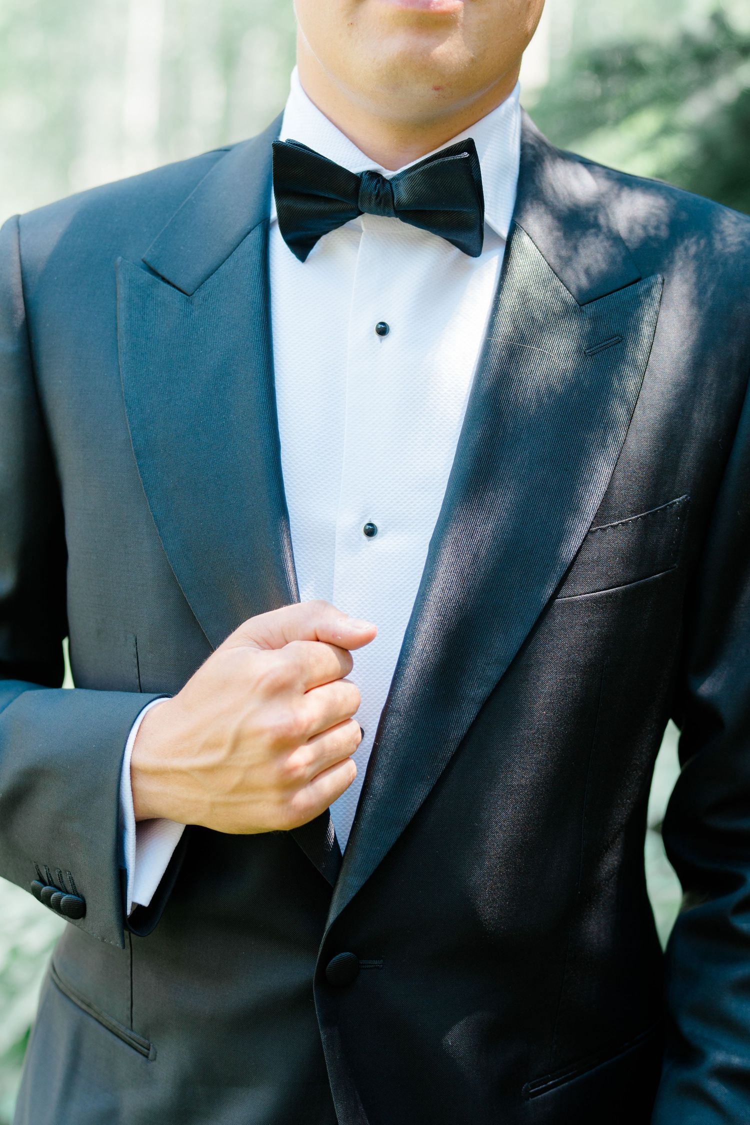Close-up of classic black tuxedo with bow tie and crisp white dress shirt in elegant formal attire.
