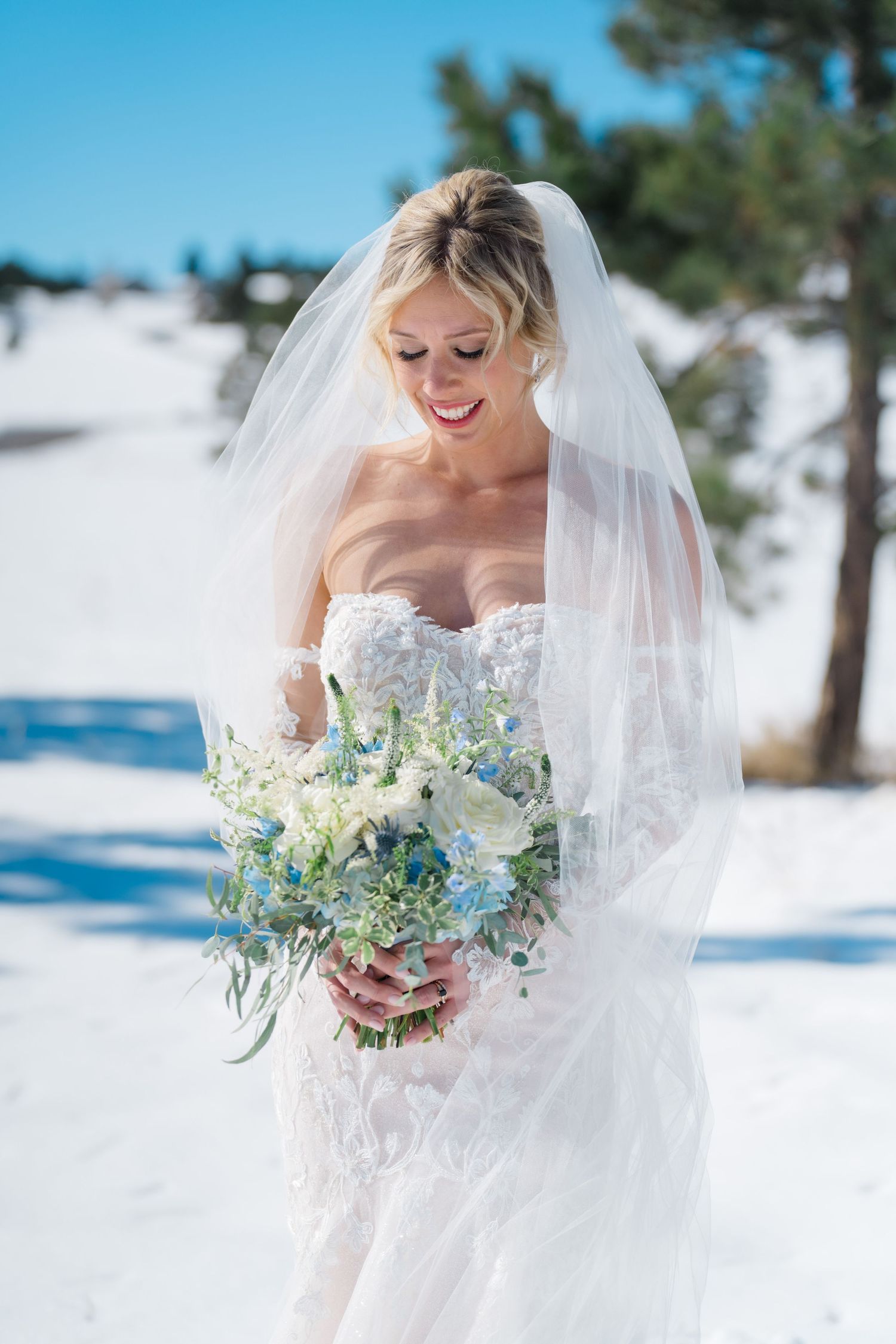 bride looking down at flowers and smiling