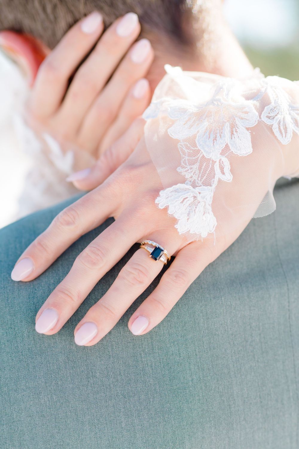 Close-up of delicate lace details and an engagement ring against a gray background by vail wedding photographer.