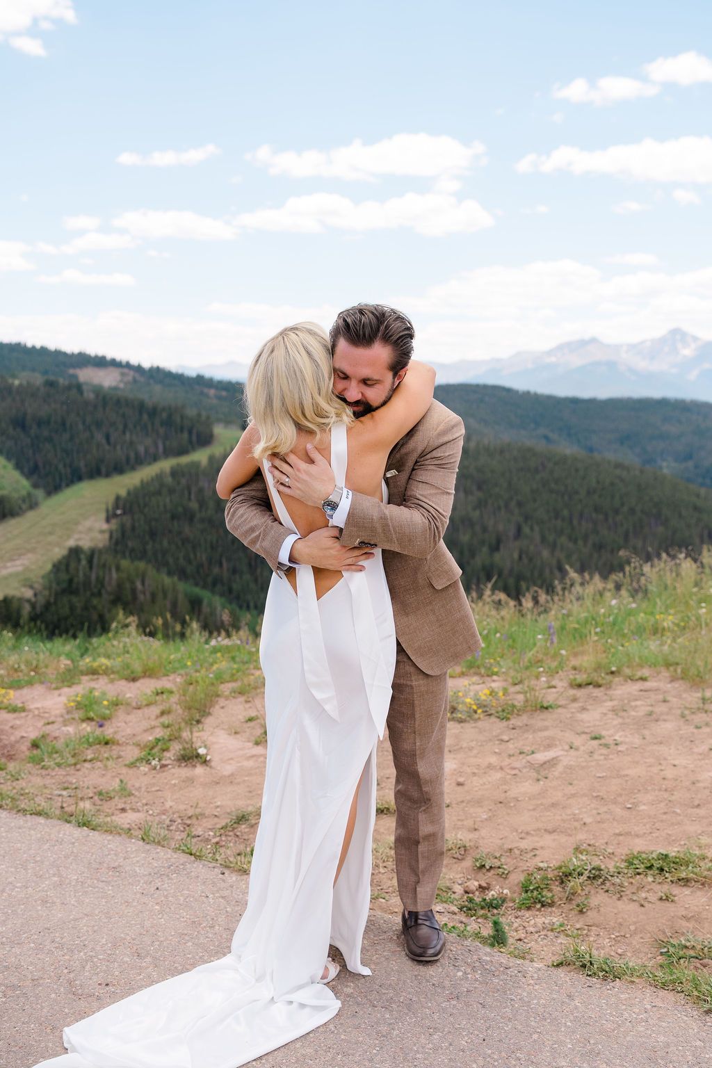 Bride and groom share an emotional hug on a mountain overlook before their Grand Hyatt Vail wedding