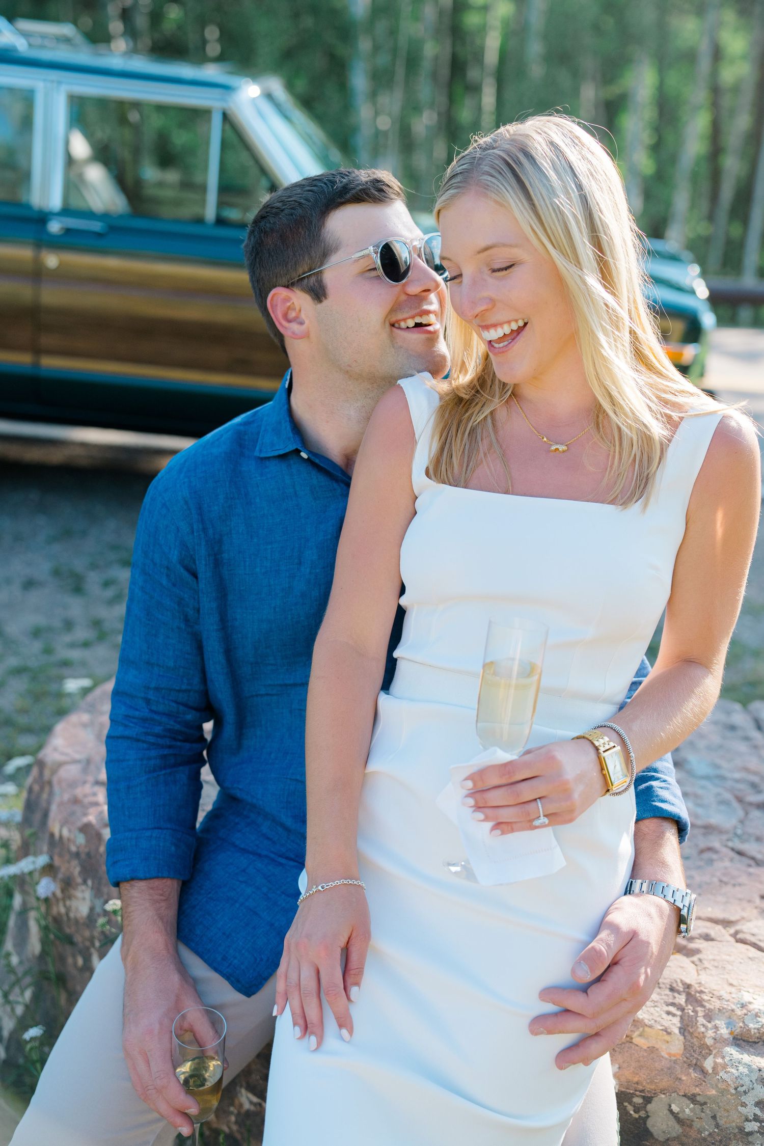 guy and girl smiling with champagne after they got engaged