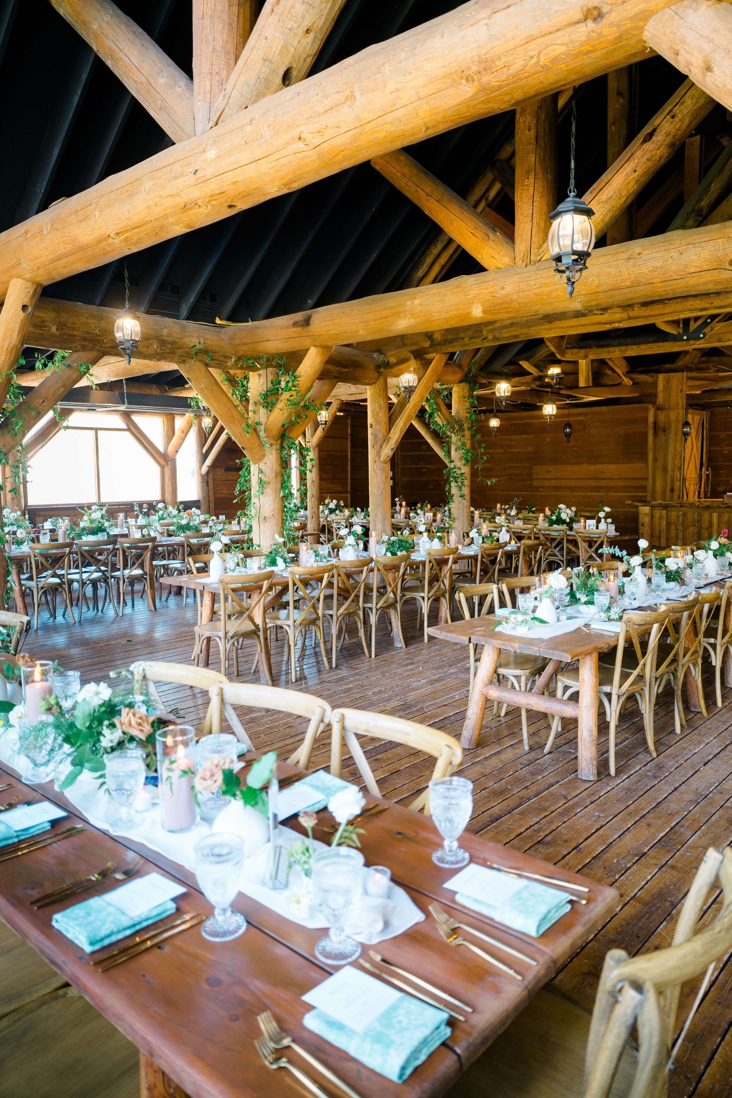 Piney River Ranch Vail Wedding - Rustic barn wedding reception with long wooden tables, cross-back chairs