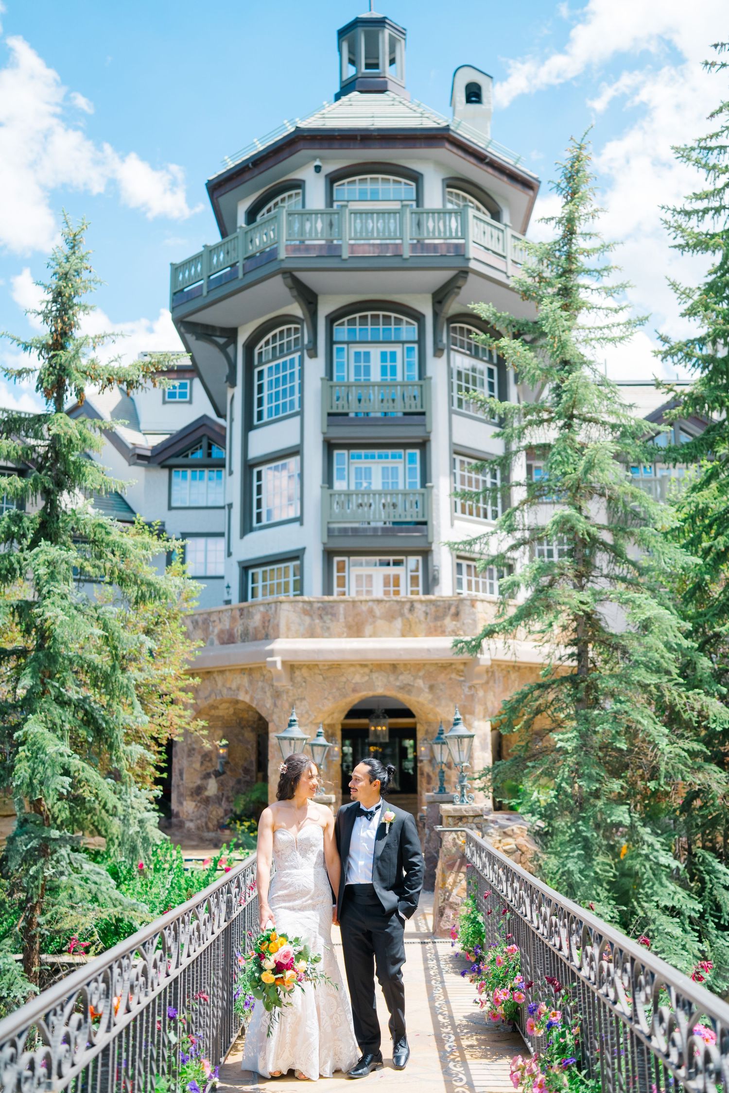 A romantic wedding photo session at a luxury mountain resort with stone architecture and evergreen trees.