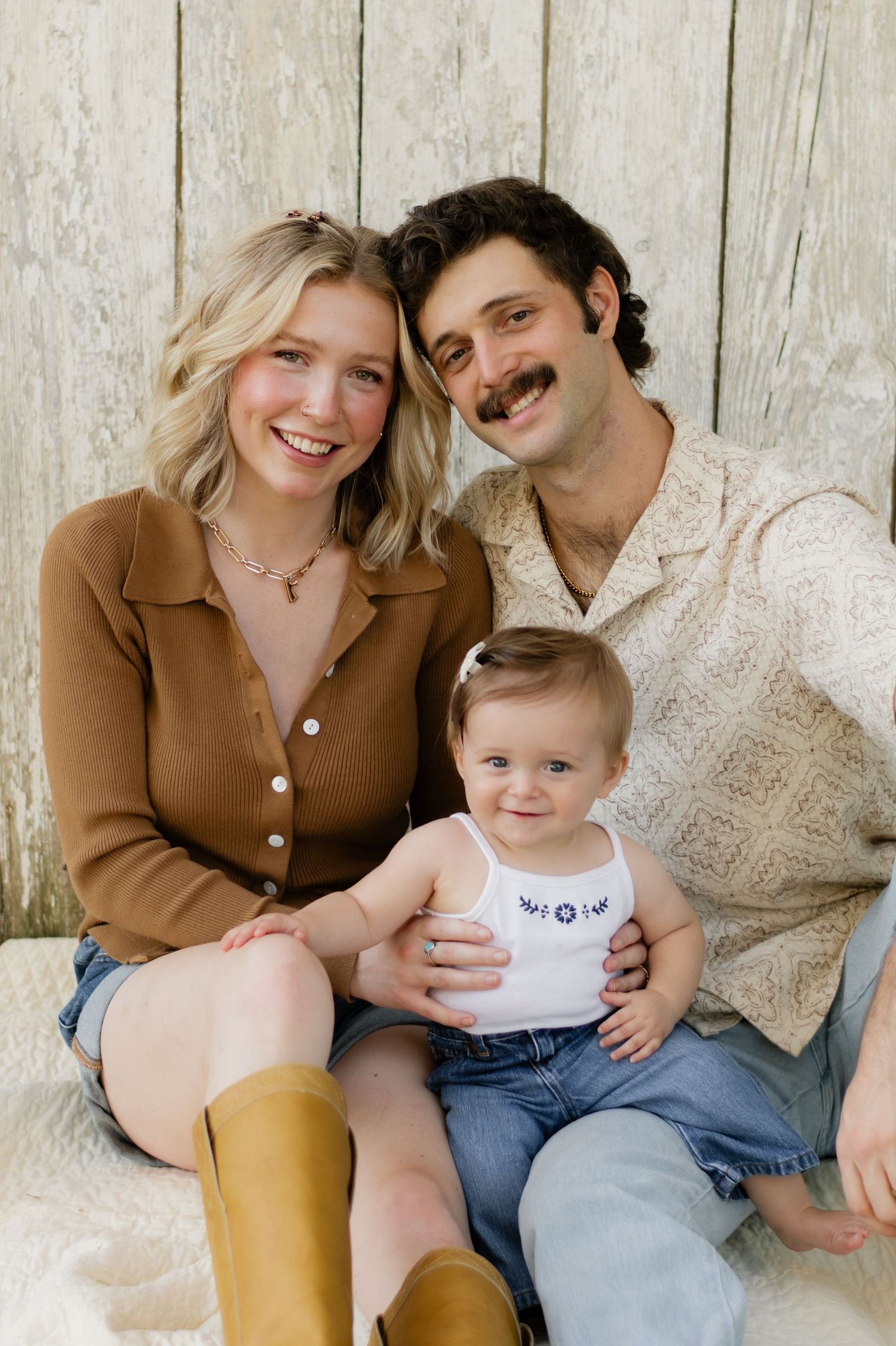 Heartwarming fall family photo outdoors — cozy sweaters, golden leaves, a playful pup, and sweet baby smiles.