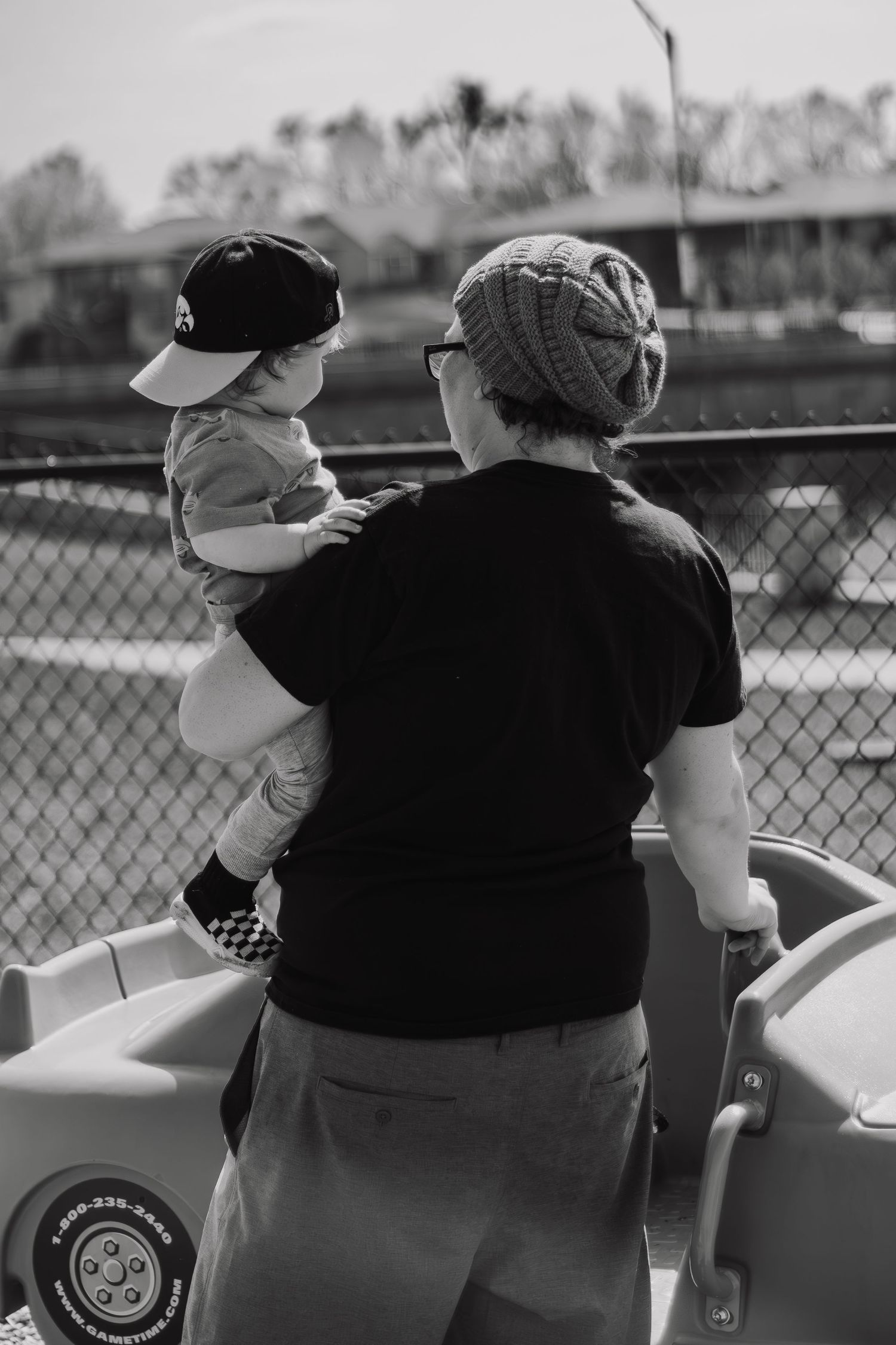 Black and white photo series showing two people sitting together at a baseball game, viewed from behind.