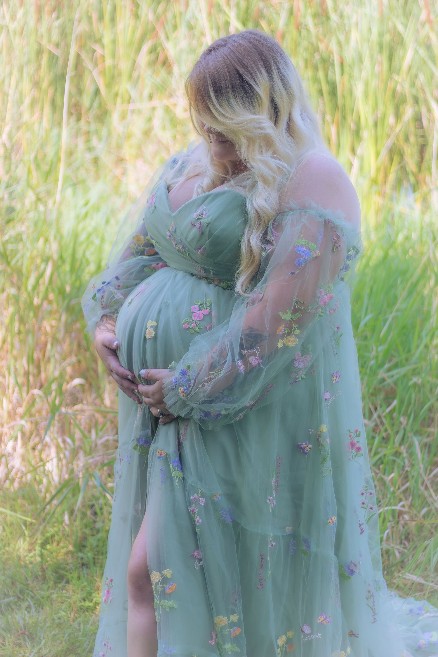 A series of tender embraces captured in soft sunlight against tall grass with figures wearing a sage green floral dress.
