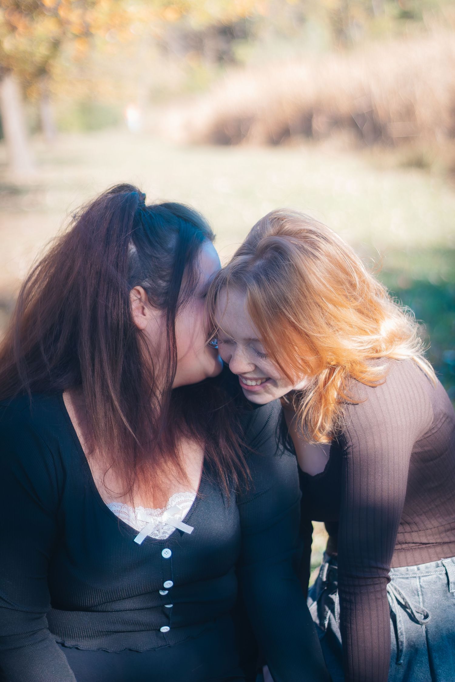 Two figures in dark clothing lean towards each other in a series of intimate, artistic outdoor portraits.