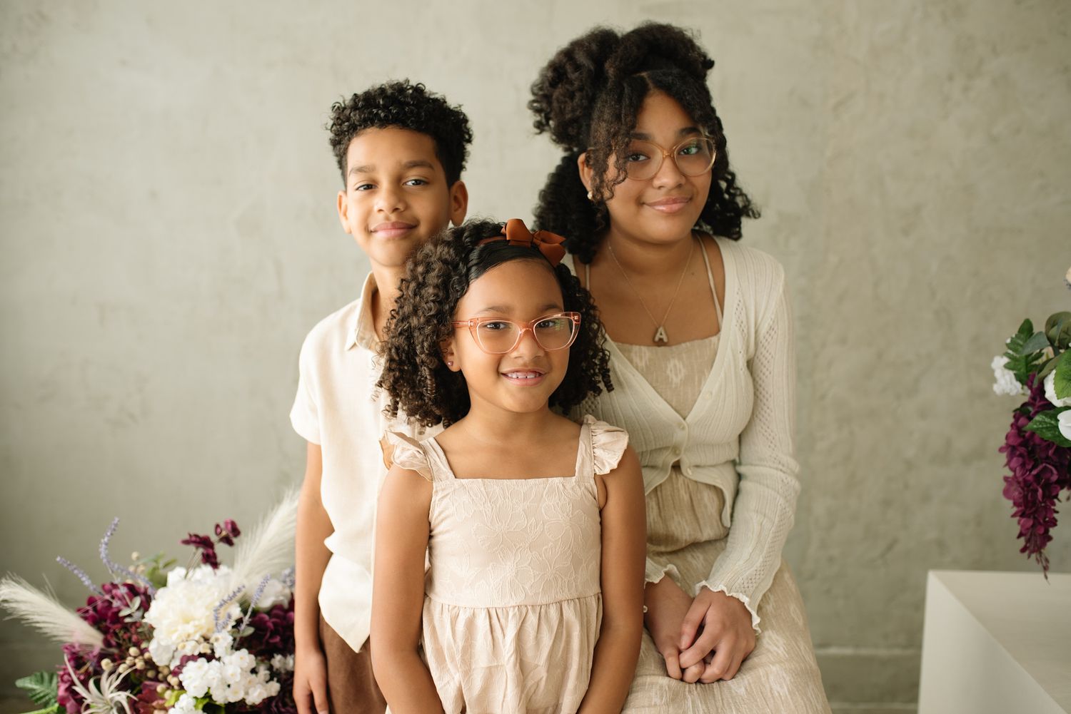 three kids giving mom her flowers