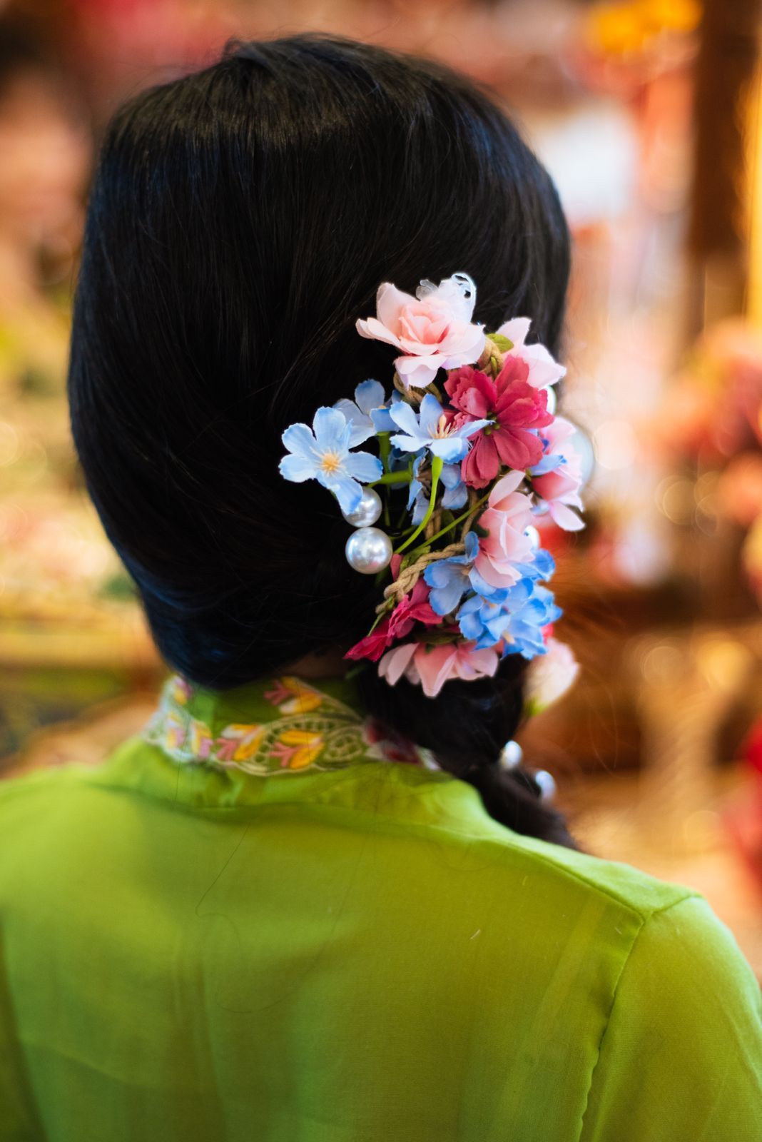 Hair adorned with delicate pink and blue flowers against a green background from different angles.