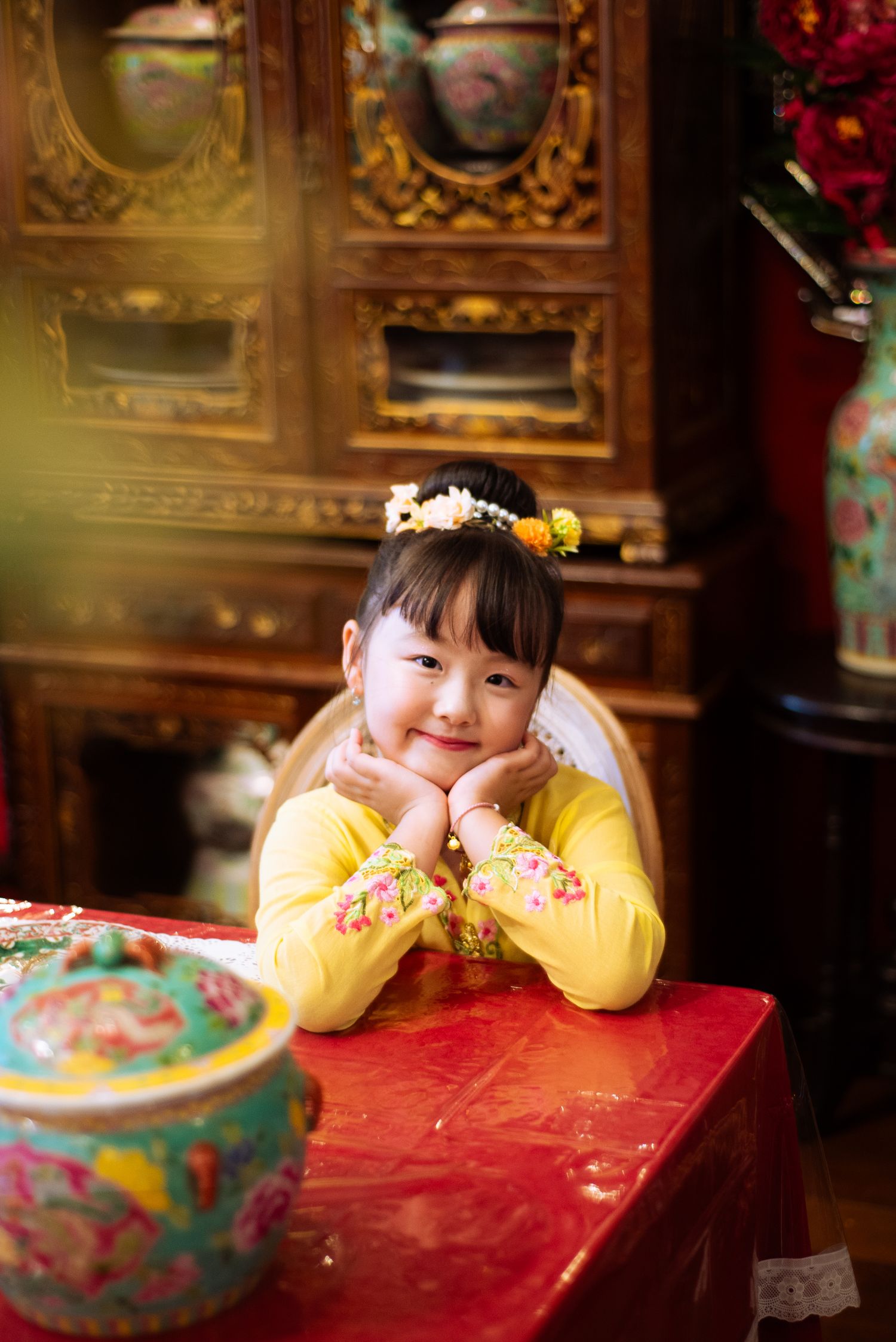 A red table setting with yellow decorative elements creates a warm Asian-inspired atmosphere.
