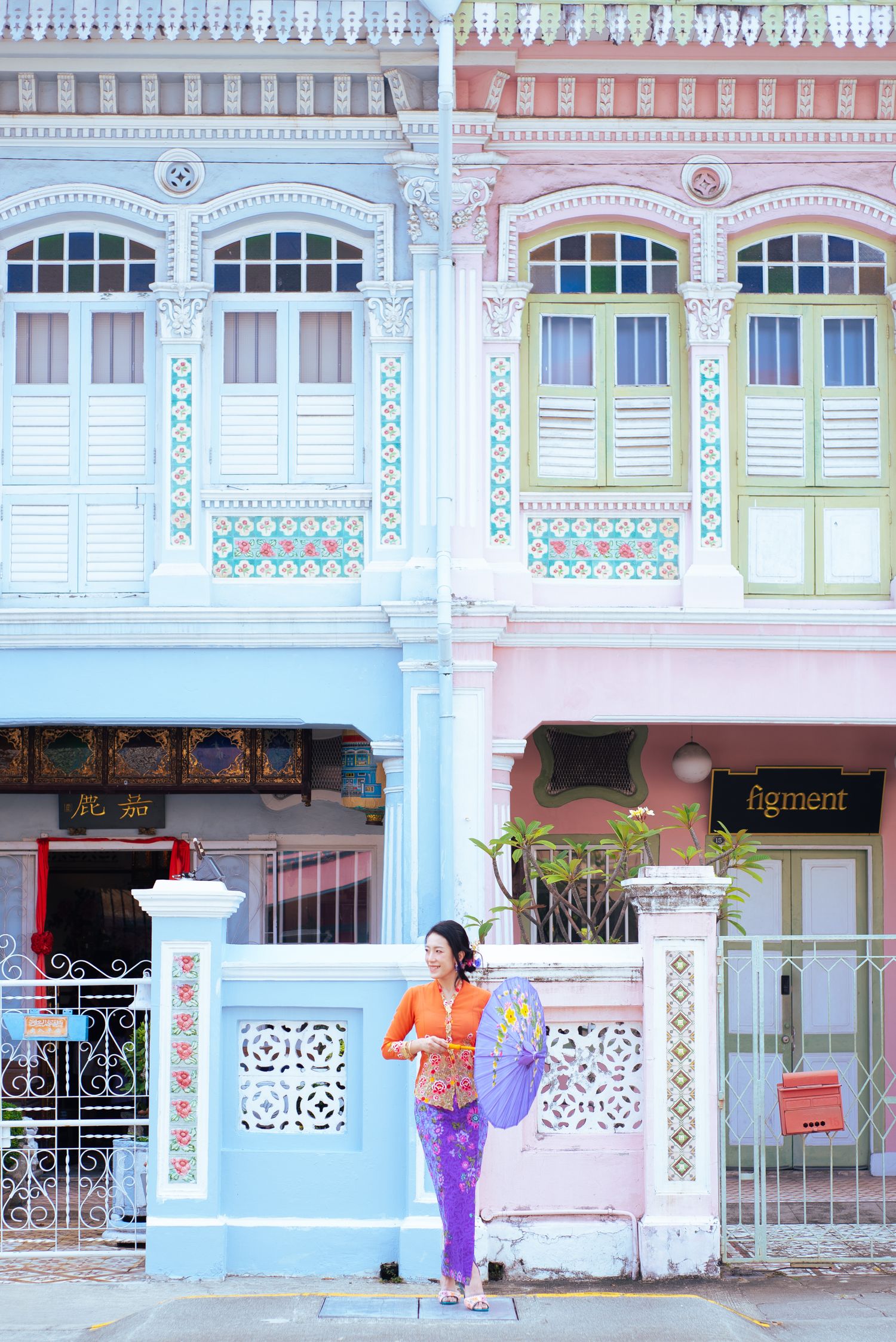 Colorful traditional Peranakan shophouse architecture in pastel blue and pink with ornate details in Singapore.