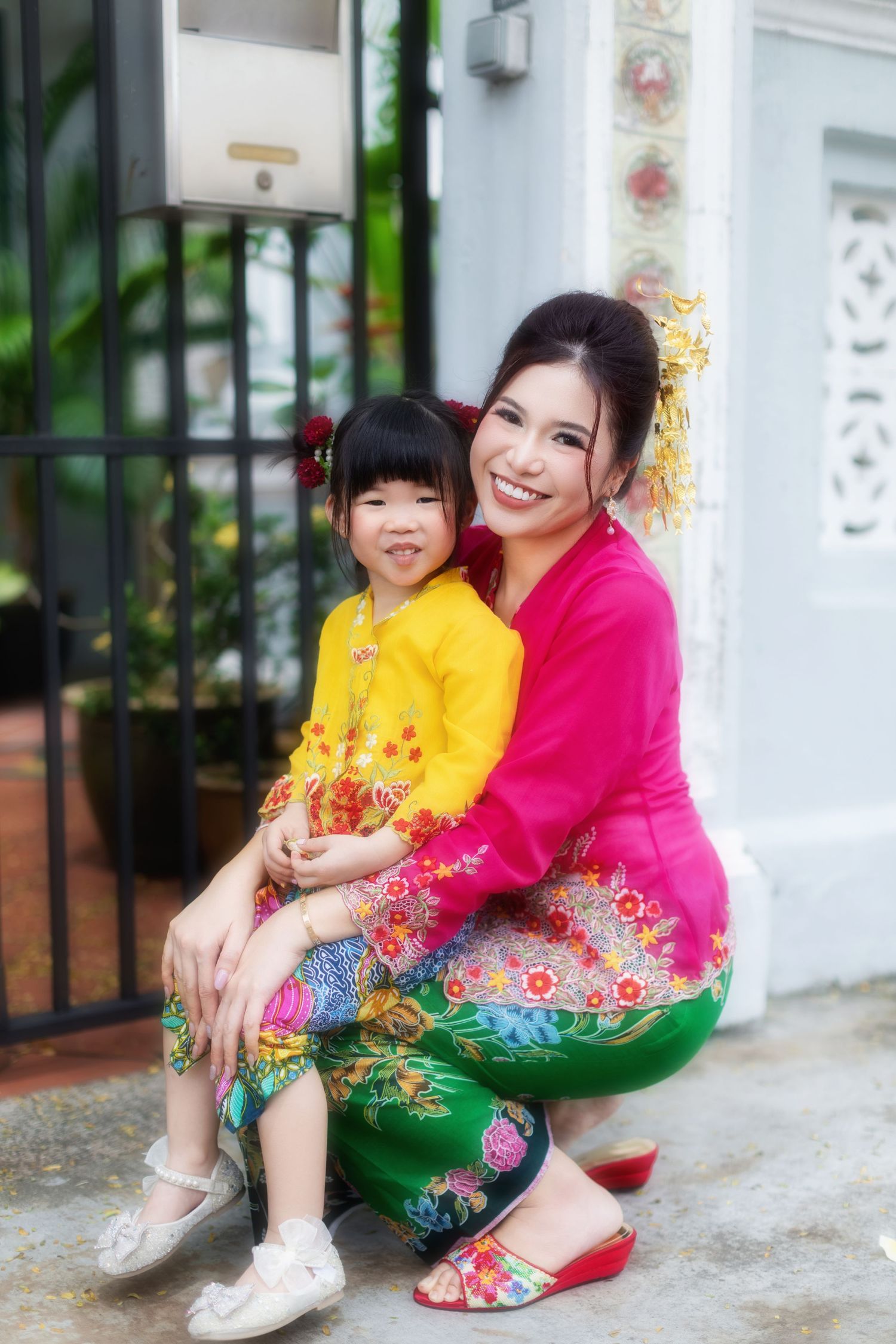 Photo of a Nyonya mummy and daughter in pink and yellow kebaya, posing at a Peranakan house at Joo Chiat, at Koon Seng road.