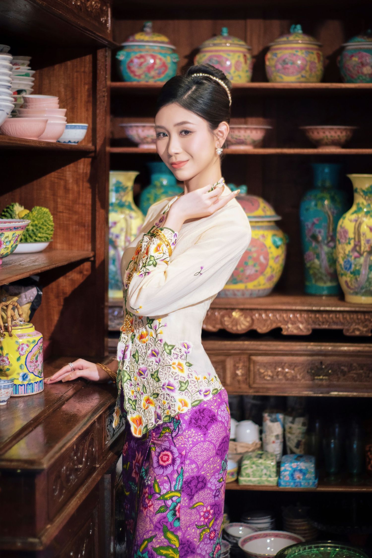 Traditional Asian porcelain shop interior with colorful vases and pottery displayed on wooden shelves.