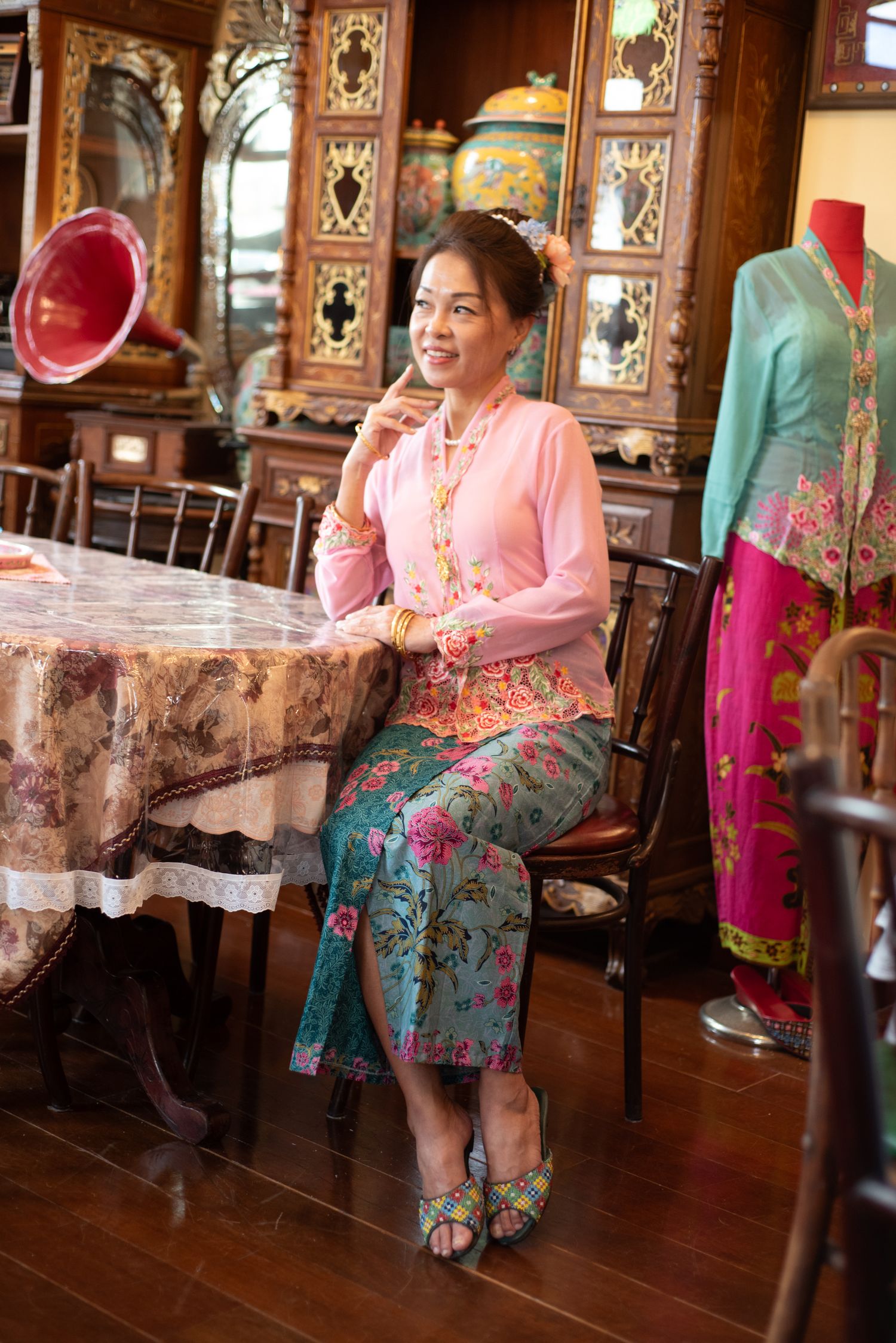 Sequence of shots showing traditional cultural celebration with guests wearing colorful Peranakan-style clothing in historic interior.