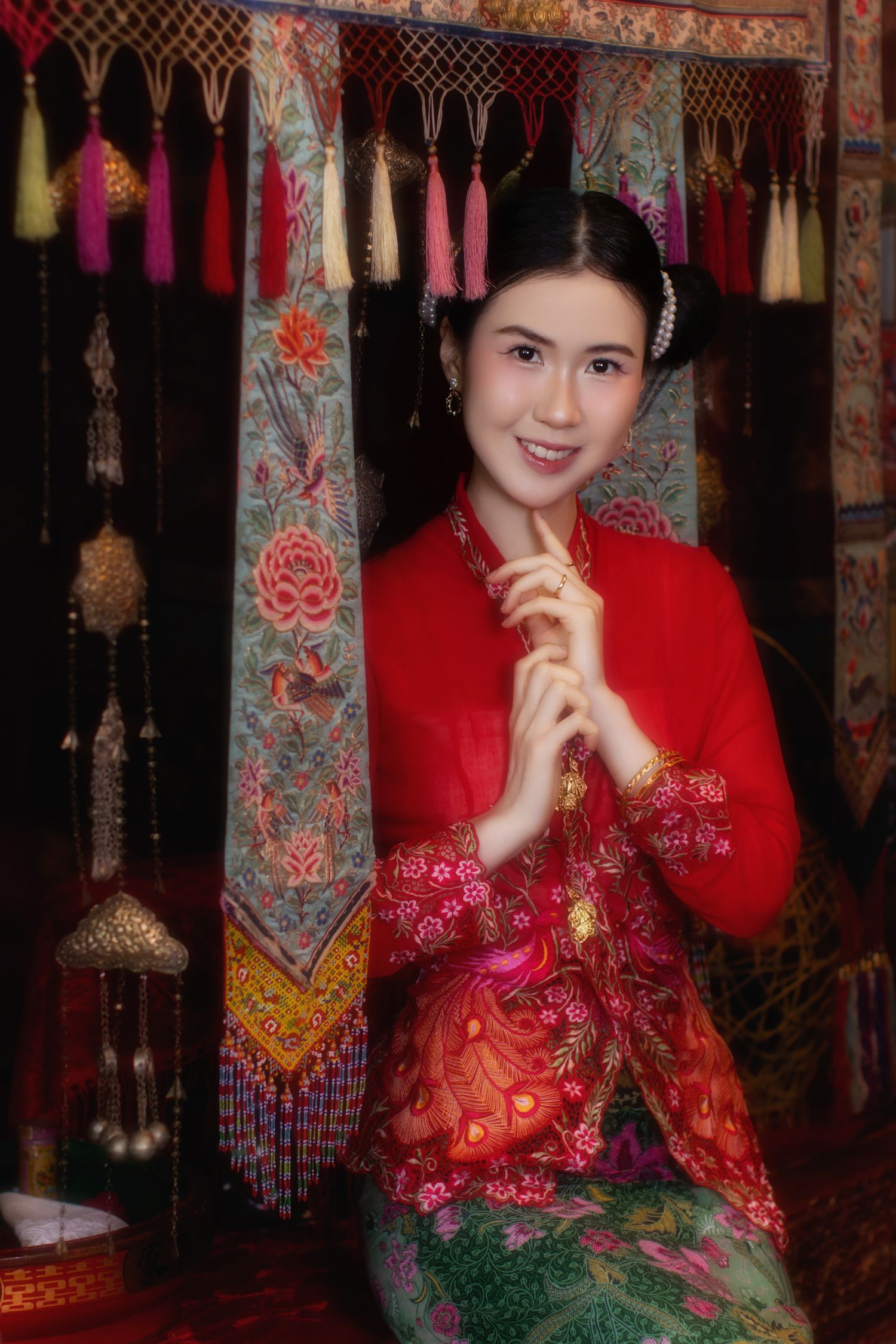 Photoshoot of a Nyonya in a red kebaya, sitting on an antique Peranakan wedding bed, inside a Peranakan Museum,, at Joo Chiat.