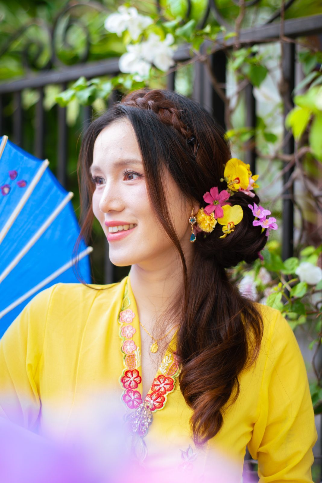 A series of images showing a yellow dress with floral details and bright colorful flowers as hair accessories.