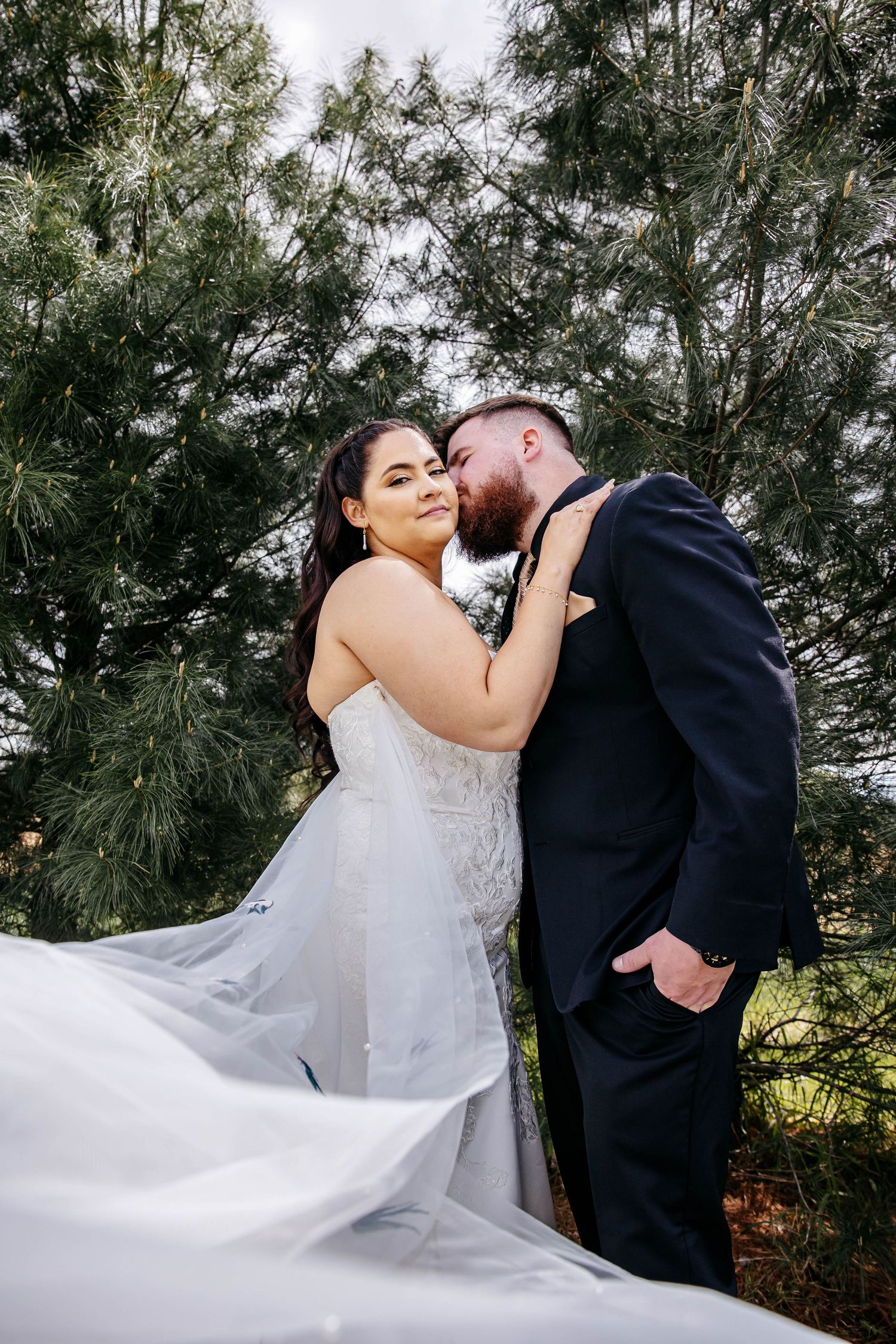 A sequence of wedding portraits shows a couple in white dress and black suit embracing against a natural pine tree backdrop.