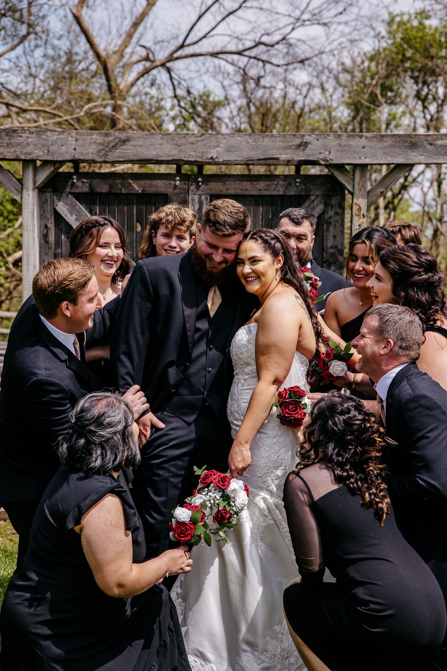 Wedding party shares candid moments of laughter and joy during outdoor photo session.