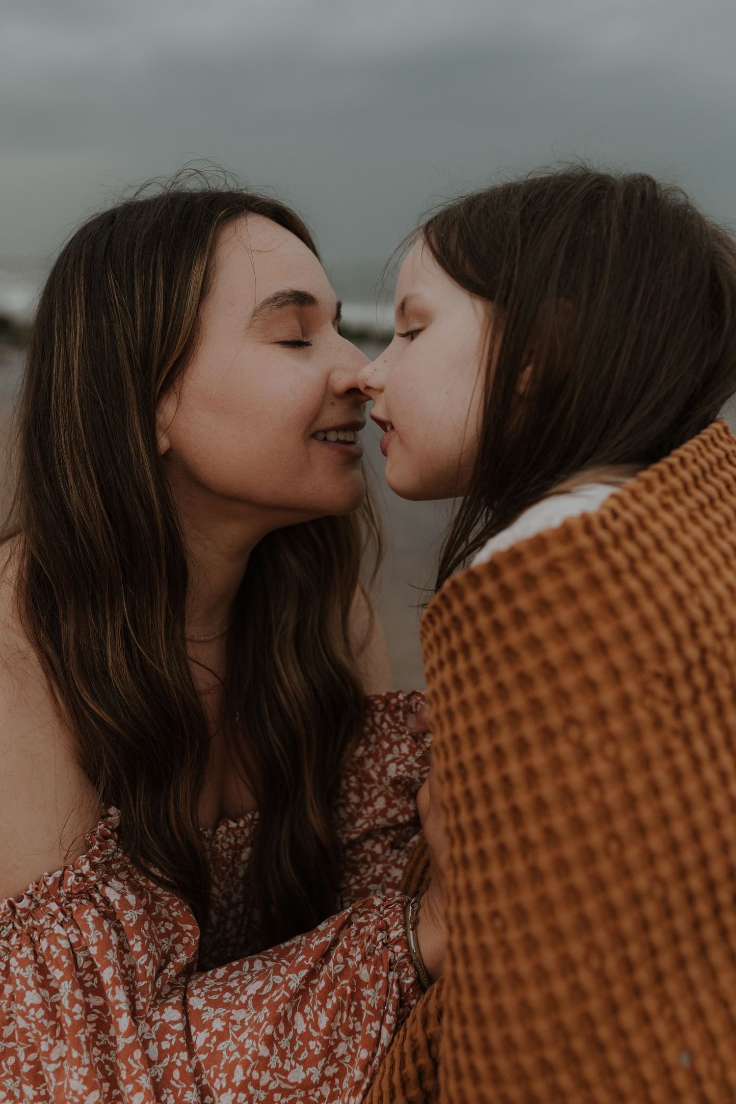A romantic couple shares an intimate moment in a series of warm-toned photos showing them getting closer to kiss.