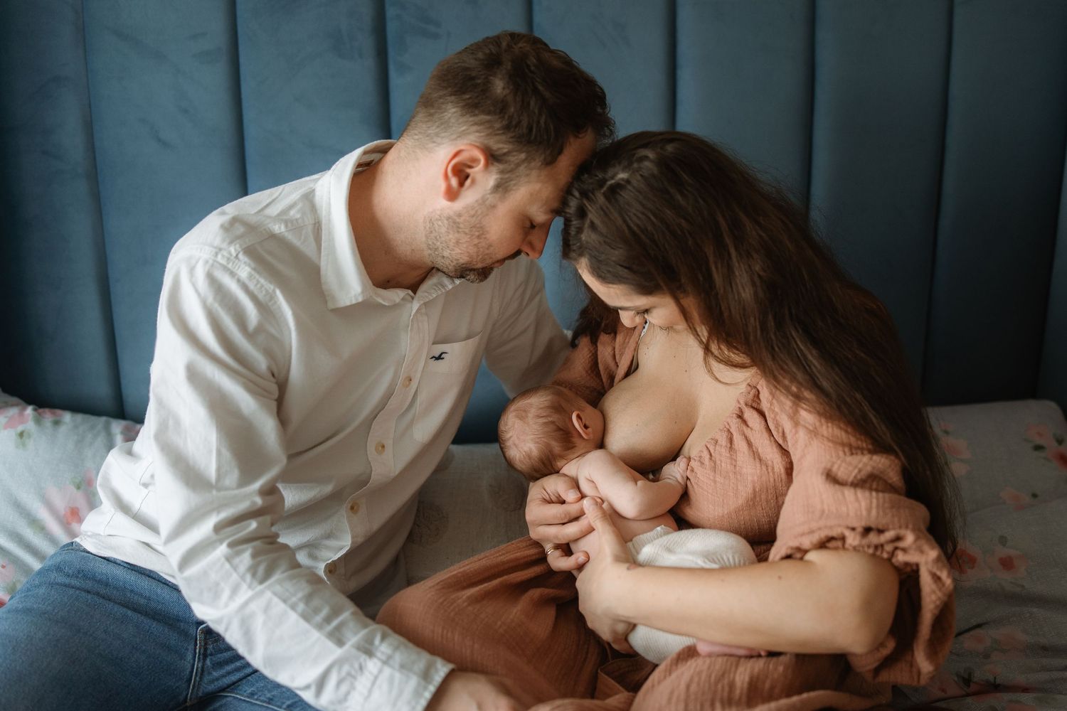 A tender moment between parent and sleeping child on a cozy bed in soft lighting.