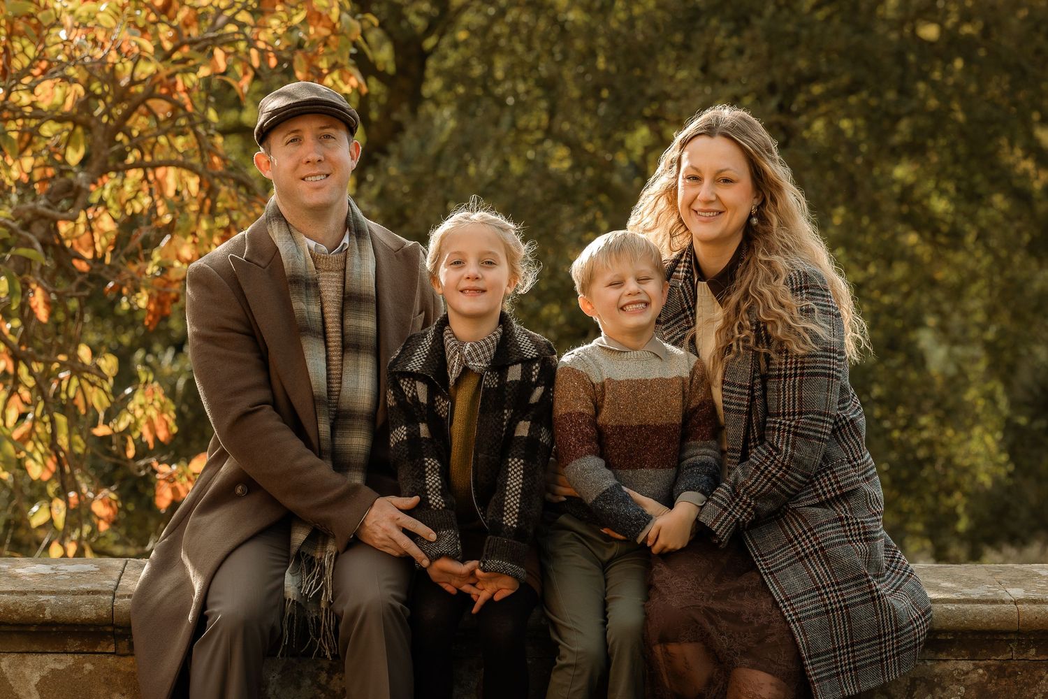 Family enjoys birdwatching together in autumn park setting with binoculars and warm clothing.