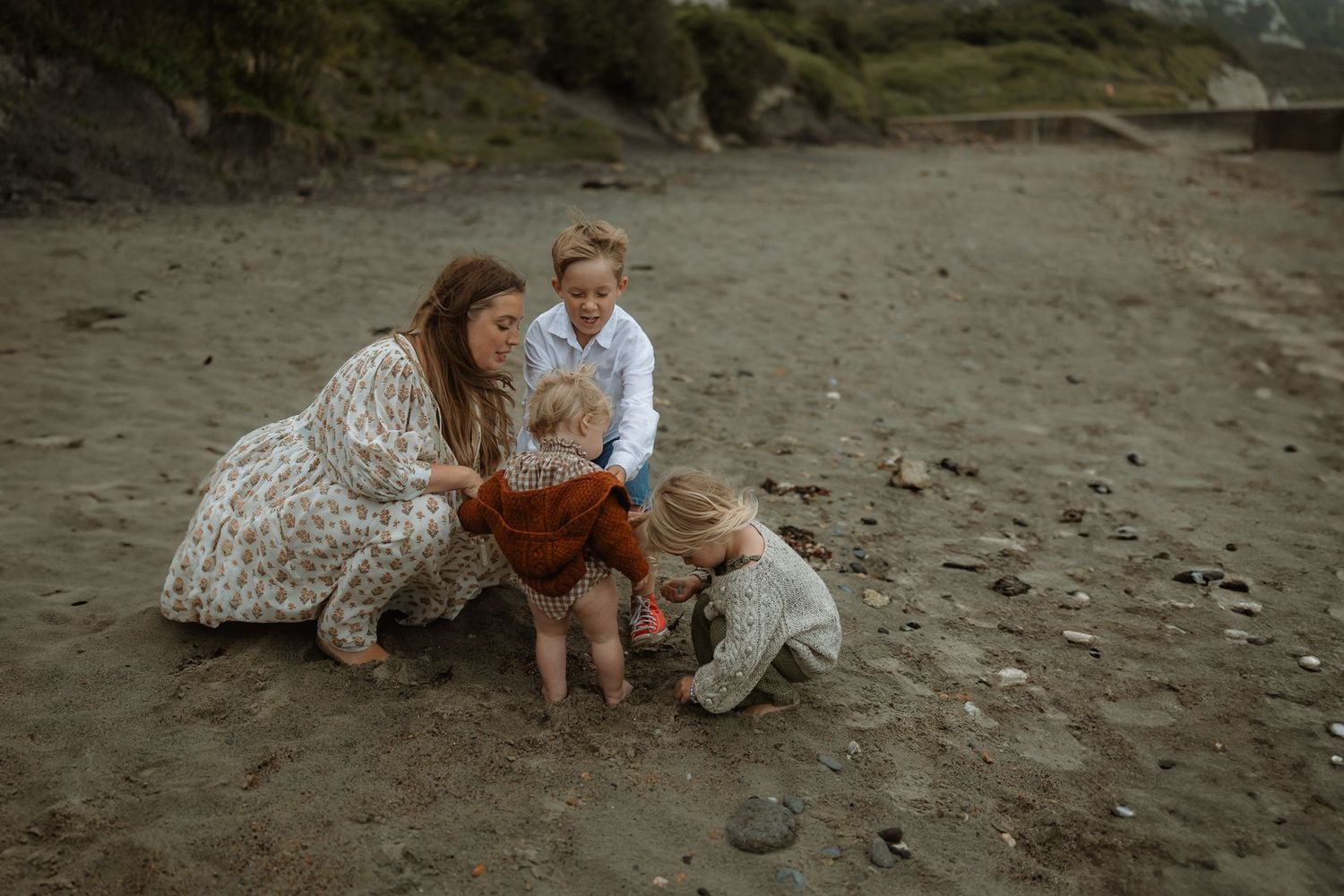 Couple shares romantic moments on a sandy beach during golden hour engagement photo session.