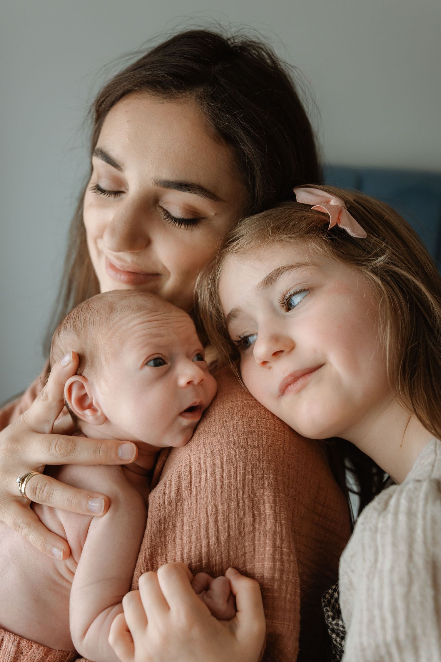 A tender moment captured in soft lighting shows a parent and baby sharing gentle cuddles and loving gazes.