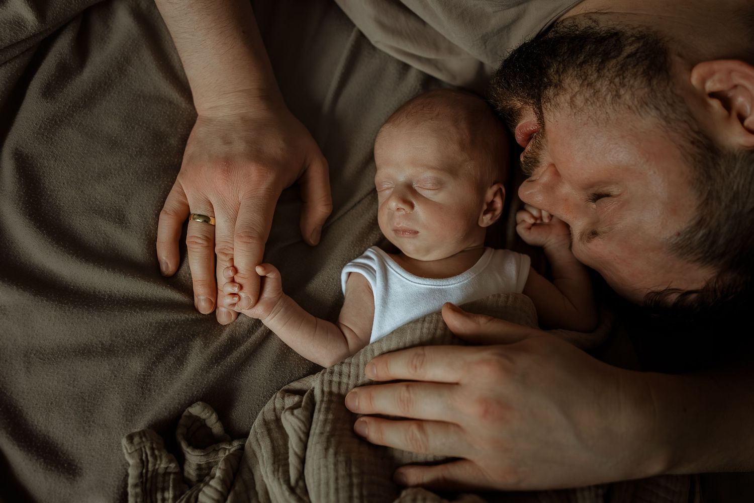 A series of intimate black and white photos showing tender moments between parent and newborn baby.