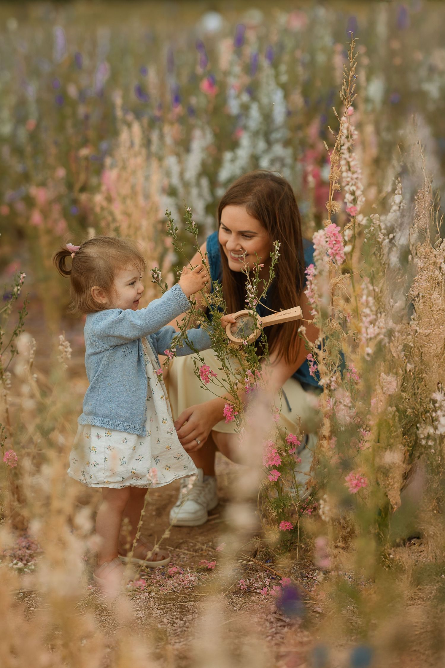 A tender moment shared between two people surrounded by wildflowers in a dreamy meadow setting at golden hour.