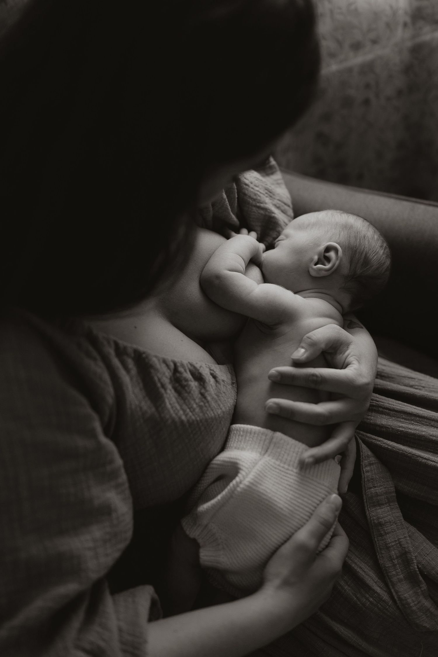 A series of black and white photographs showing a baby being gently held and cradled in a tender moment.